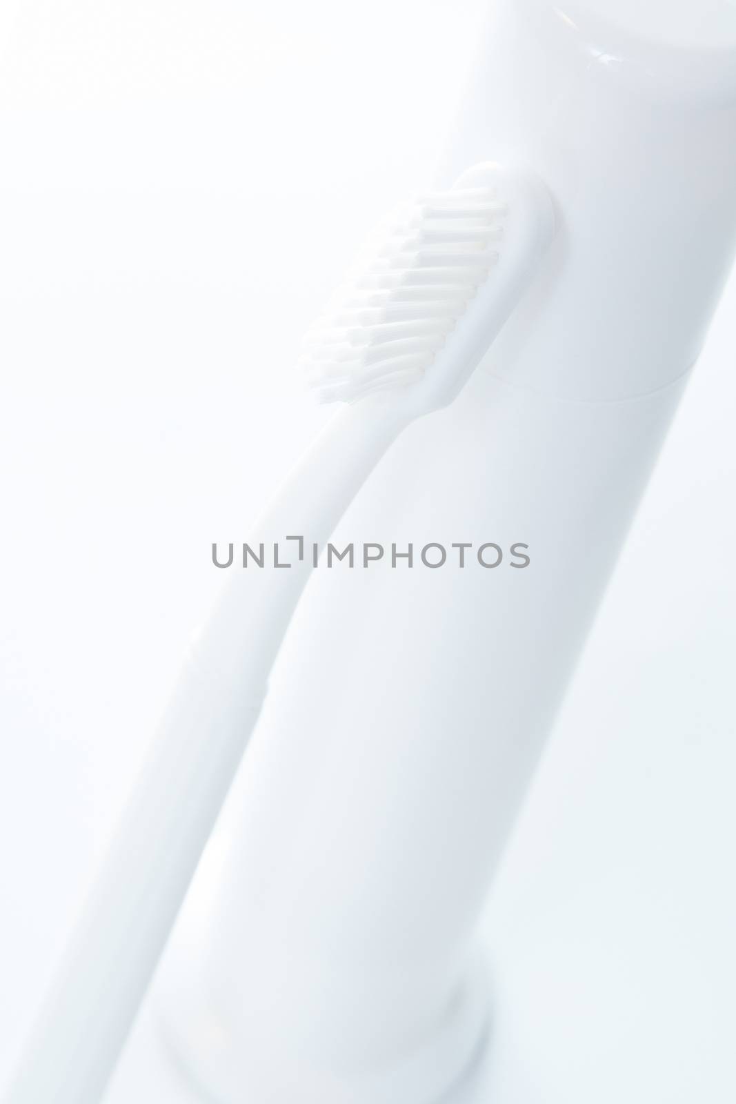 Toothpaste and toothbrush over white. Shallow DOF.
