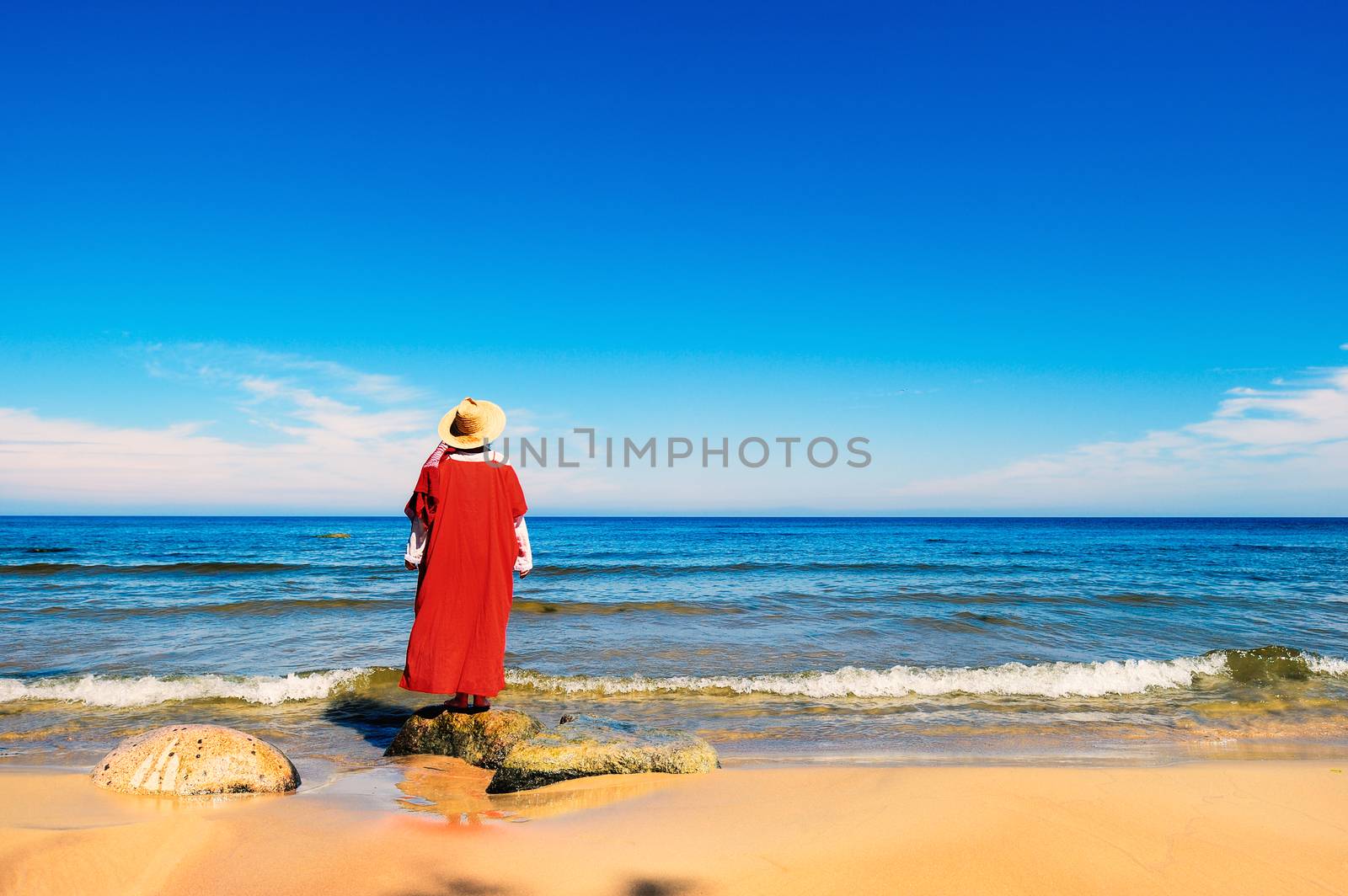 Woman in red dress on the seashore