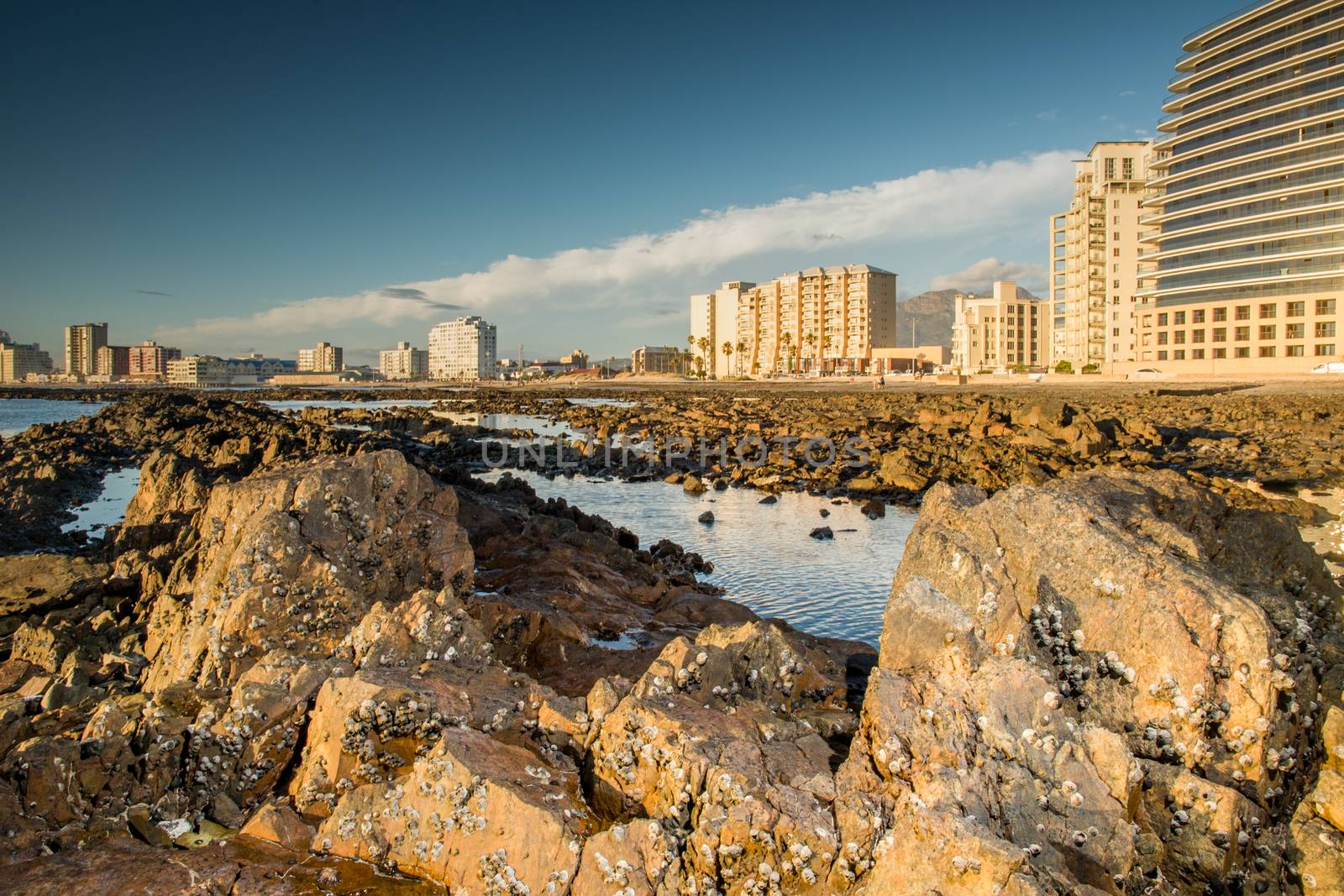 Rocky beach at Somerset West with a view to the city scape at low tide