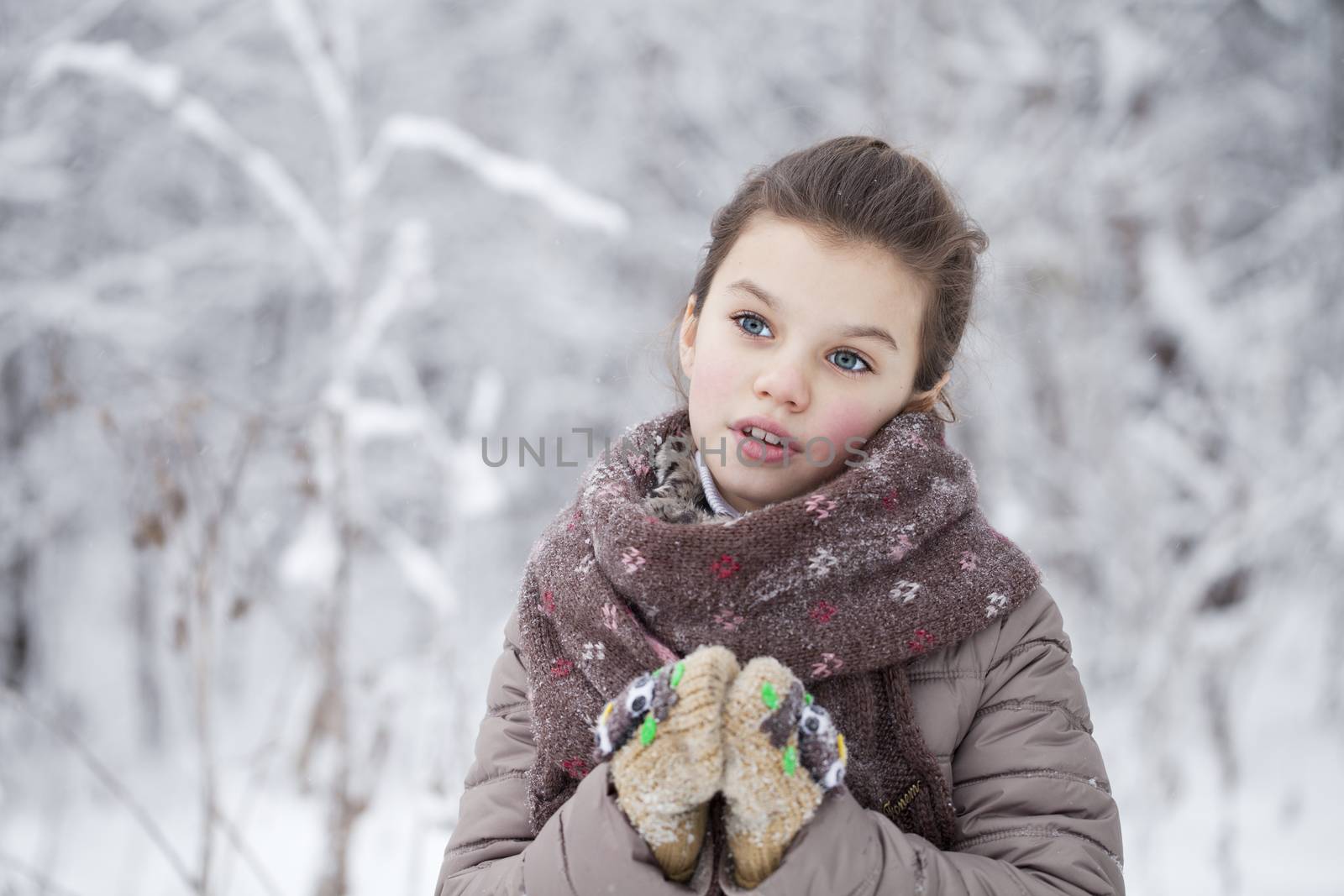 Happy little girl on the background of a winter park by andersonrise