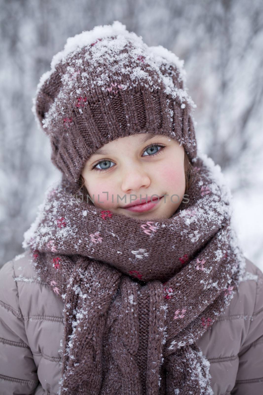 Happy little girl on the background of a winter park by andersonrise