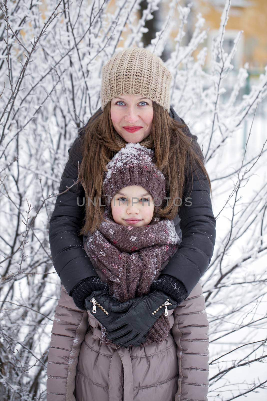 Winter portrait of a nine year girl with her mother by andersonrise