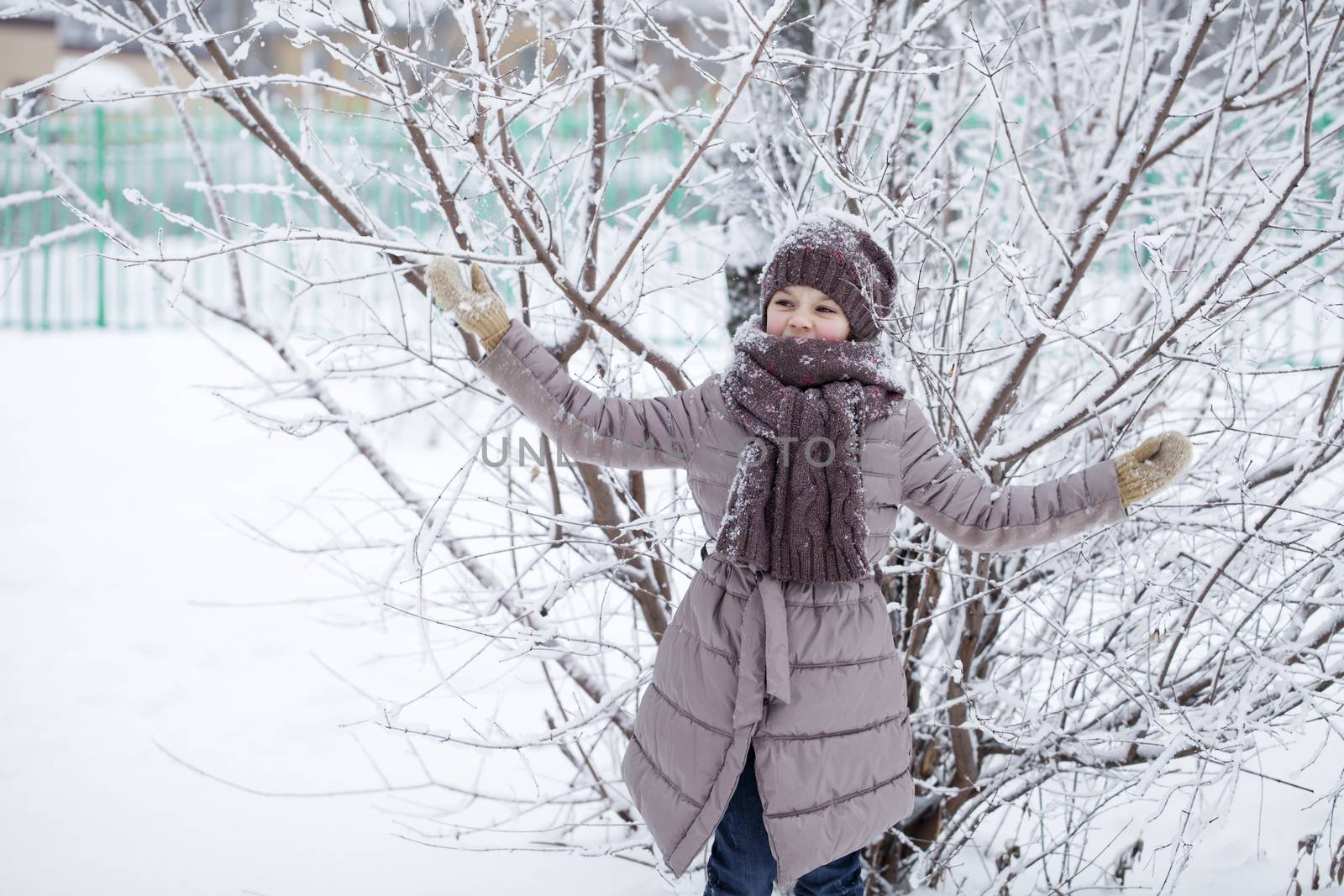 Portrait of a happy little girl on the background of a winter pa by andersonrise
