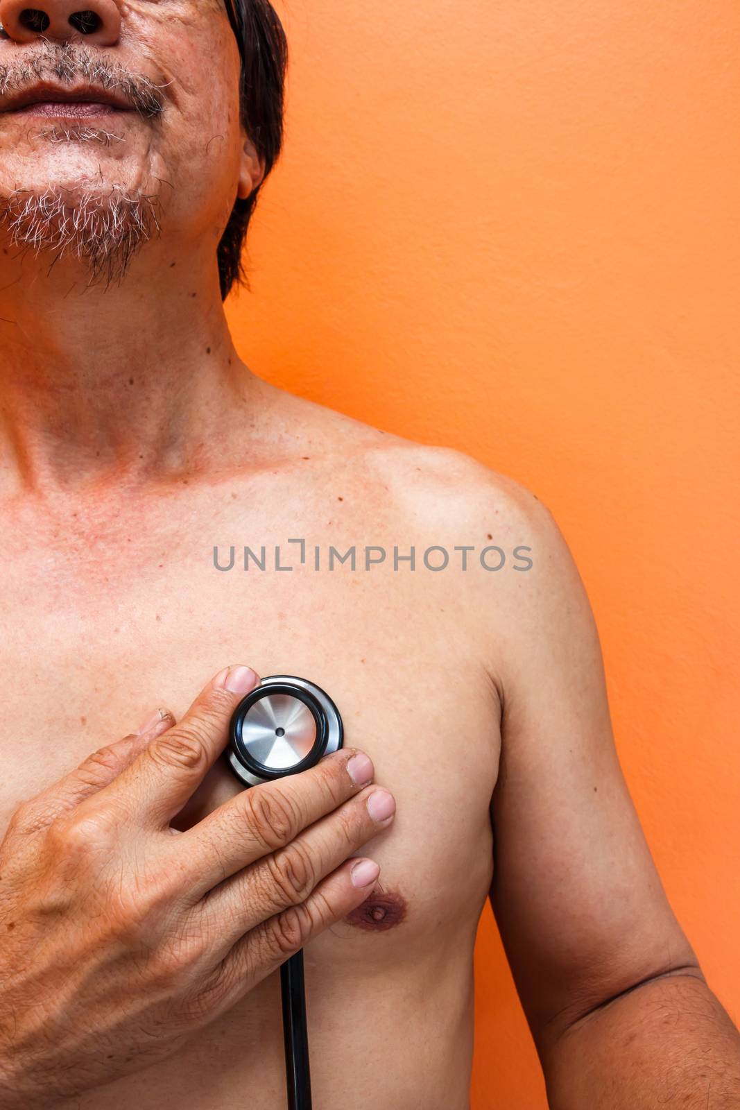 old aged asian man was diagnosed by doctor on orange background