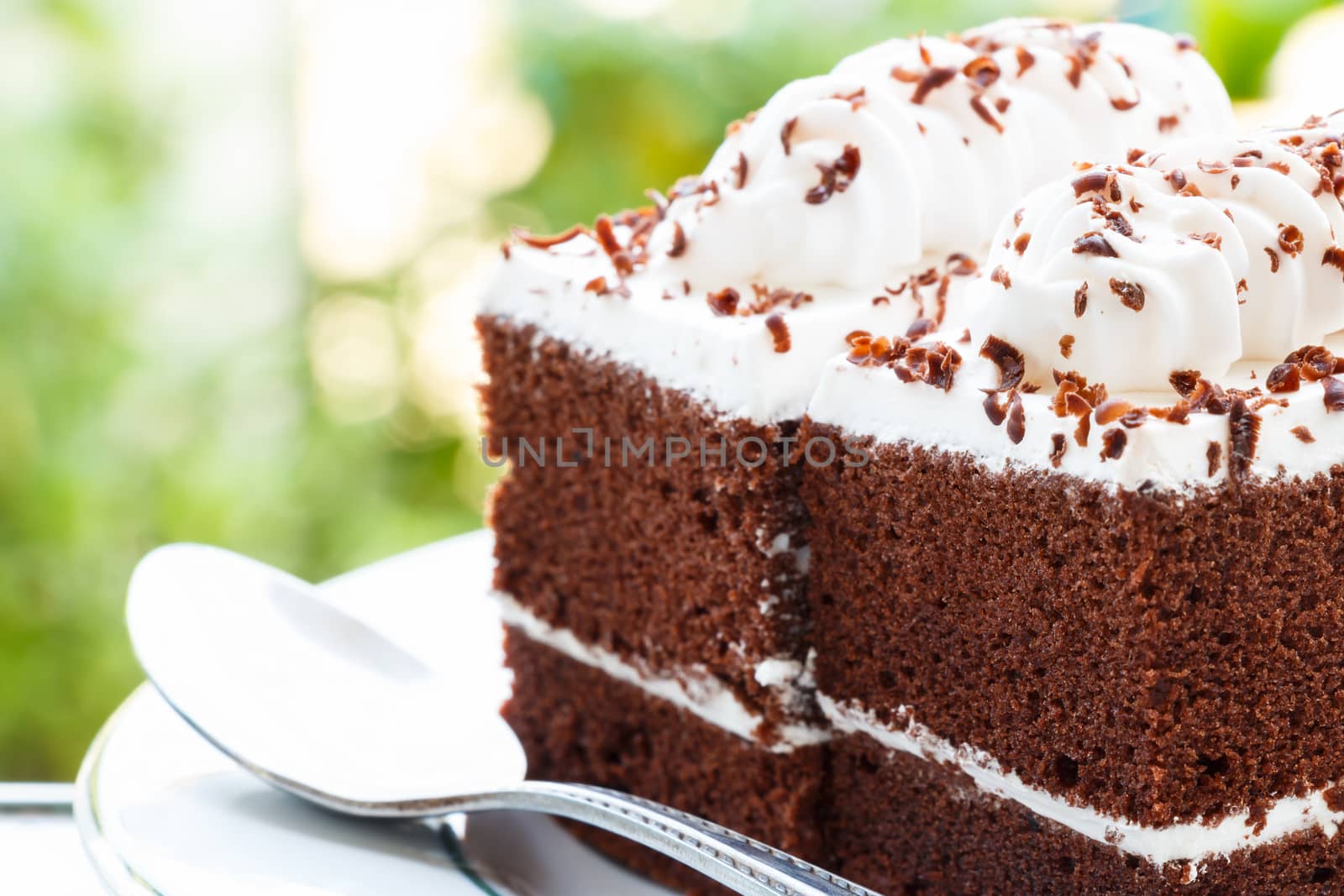 close up of chocolate cakes with white cream on top and bokeh at background