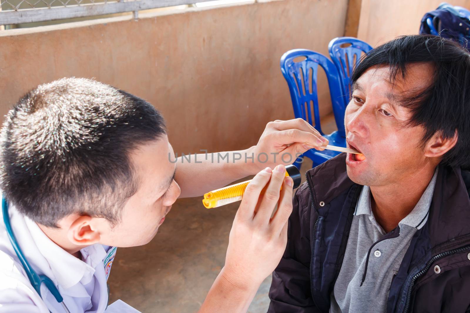 Mobile Health Units in Thailand (Young practitioner is examing patient(hill-man))