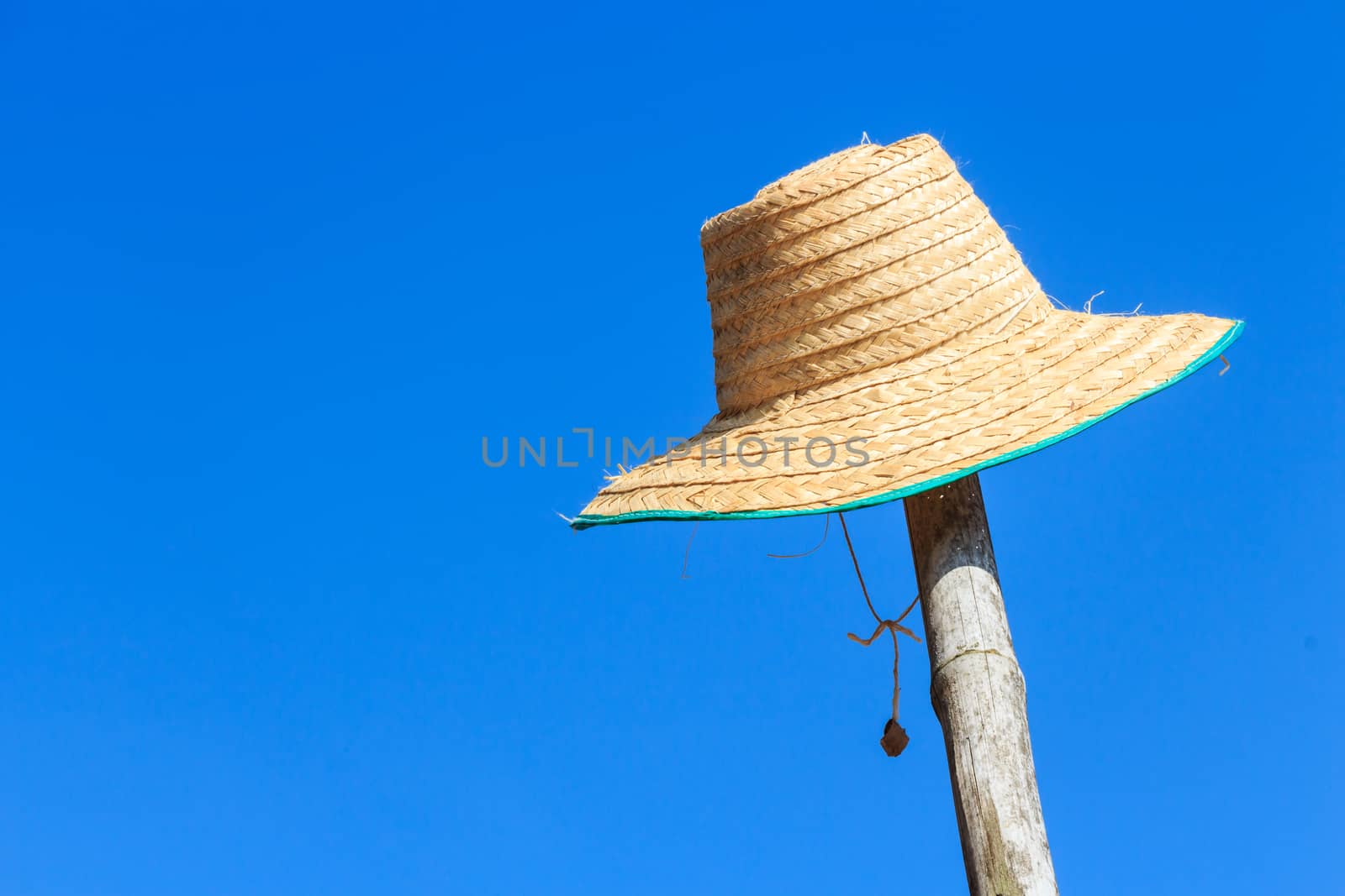 farmer's hat was hanged on bamboo and blue sky in rural ,Thailand