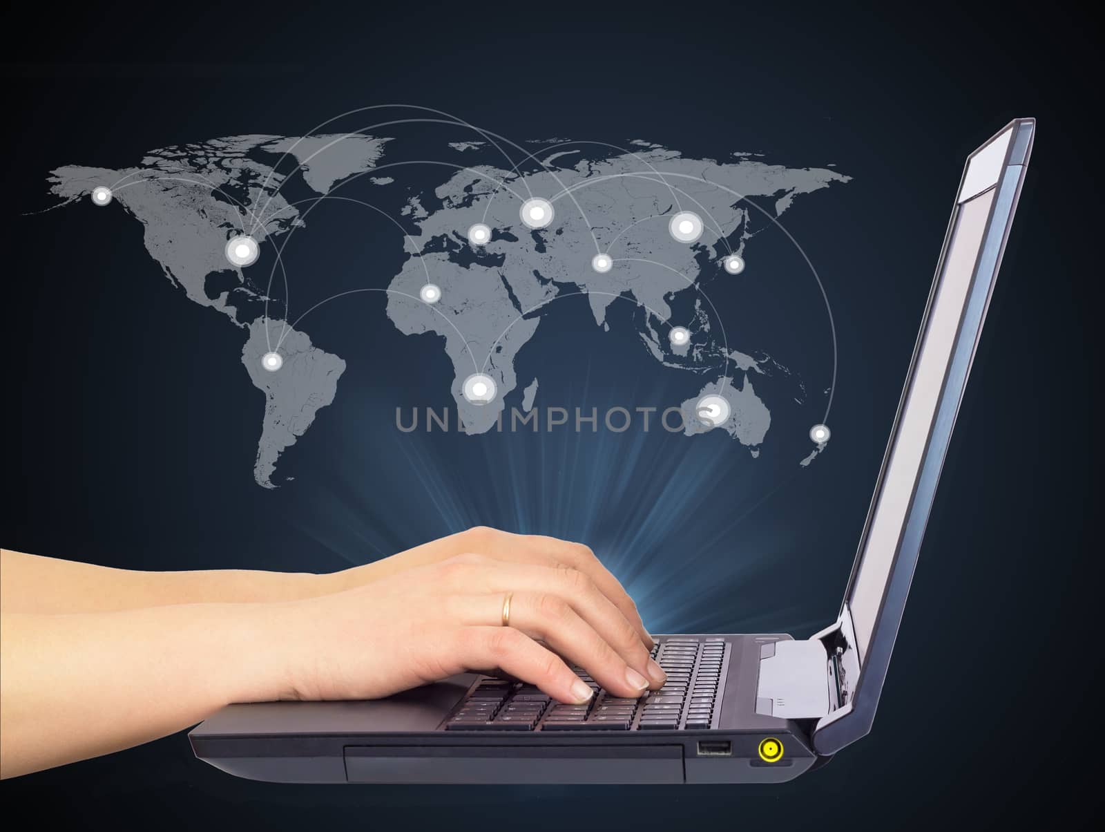 Female hands using laptop, side view. World map above, with connection points and lines. On dark background