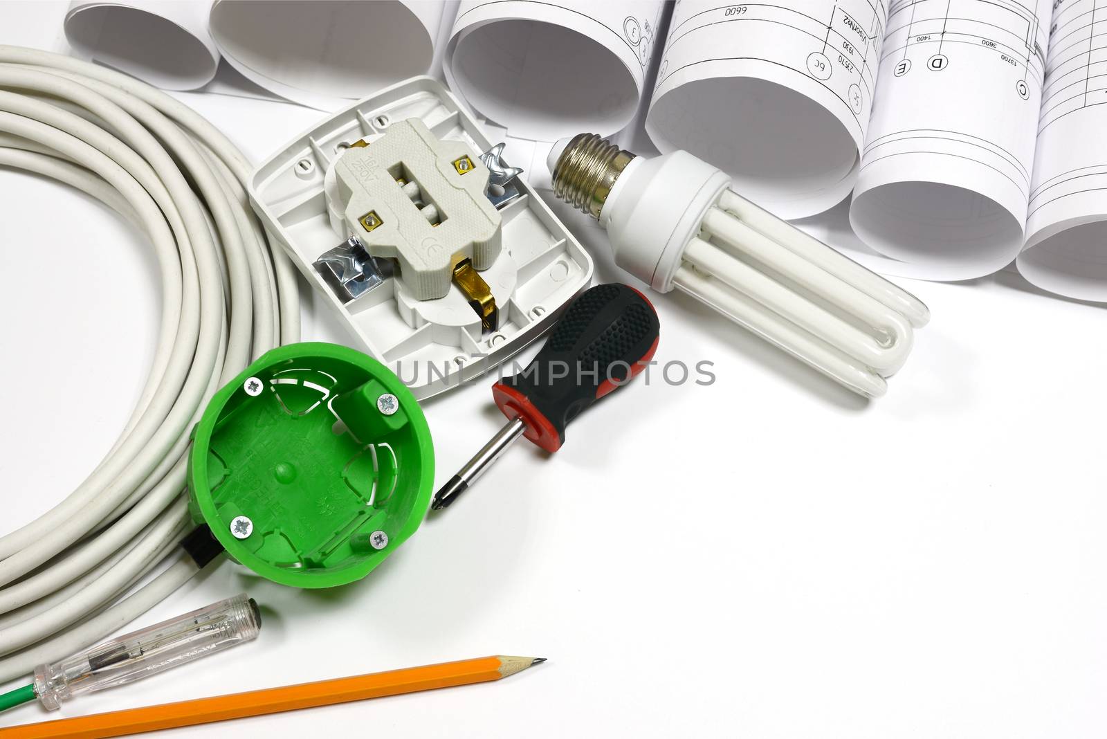 Drawing rolls, wall socket, socket box, power cable, screwdriver, lamp, test pen and pencil on white surface