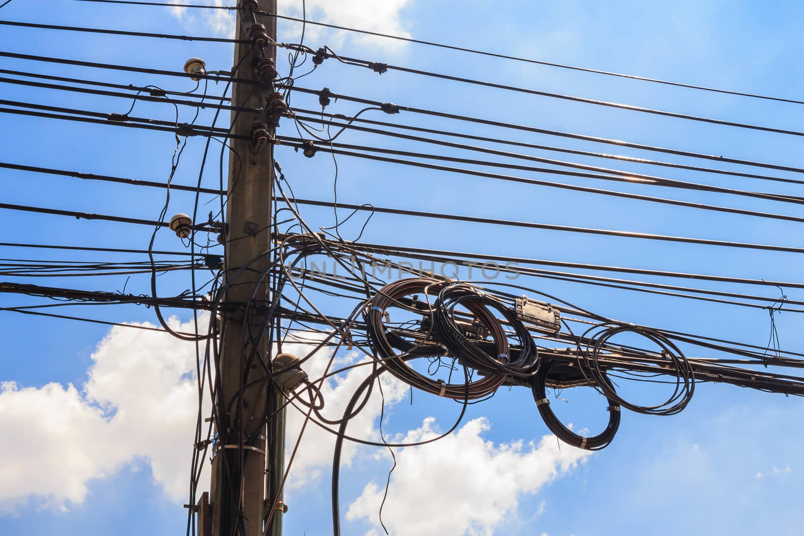 electricity post with untidy wire and blue sky