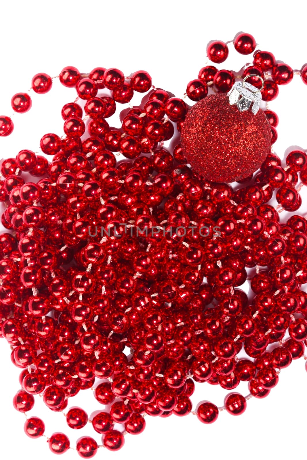 Photo shows a closeup of red Christmas beads and ornament on a white background.