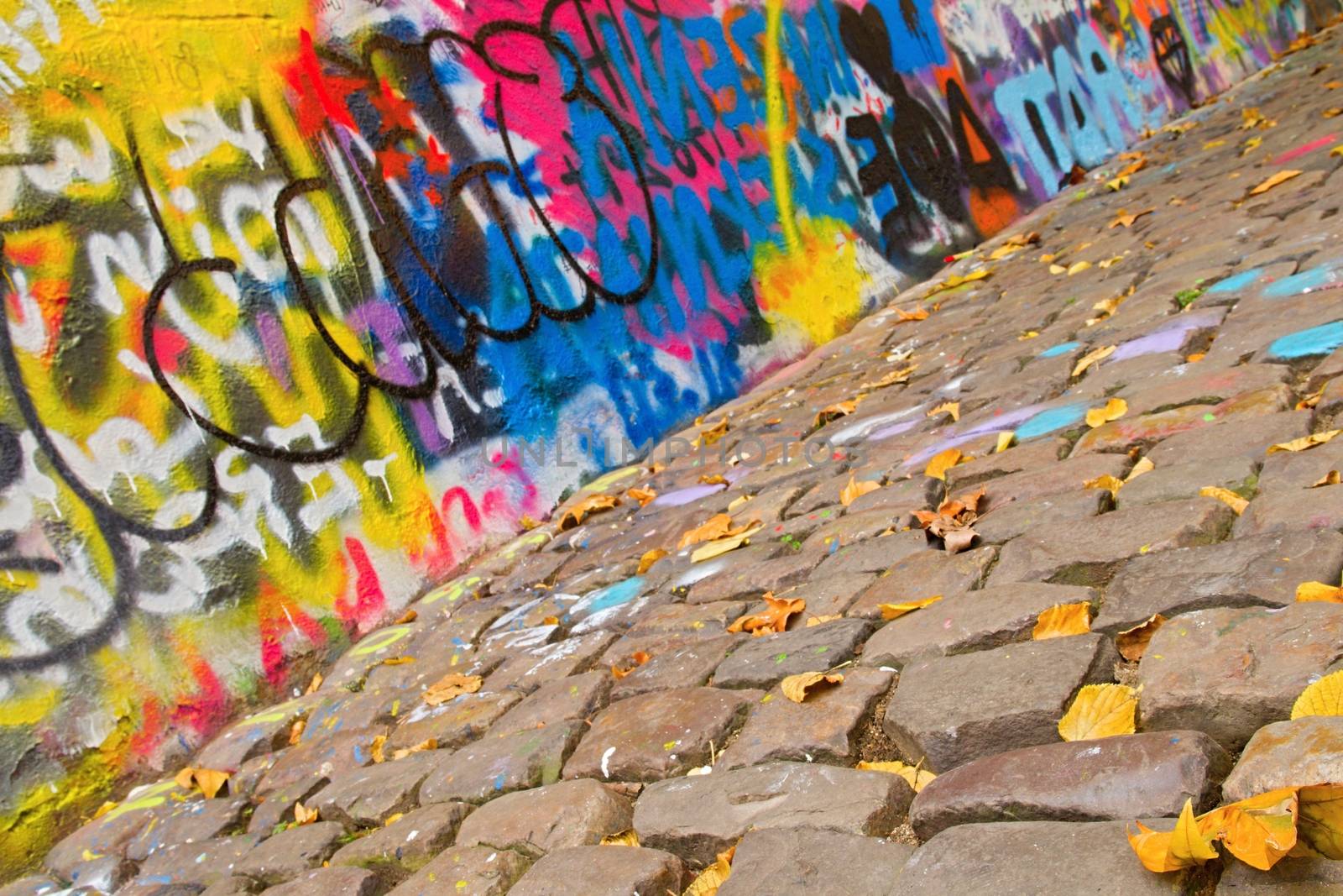 Photo shows a closeup of various drawings and paintings on the urban wall.