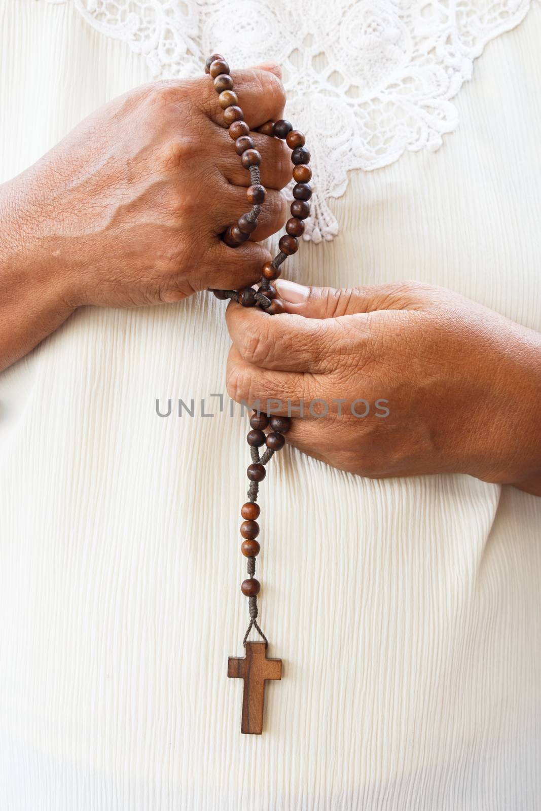 asian in white cloth hold a rosary for pray to god