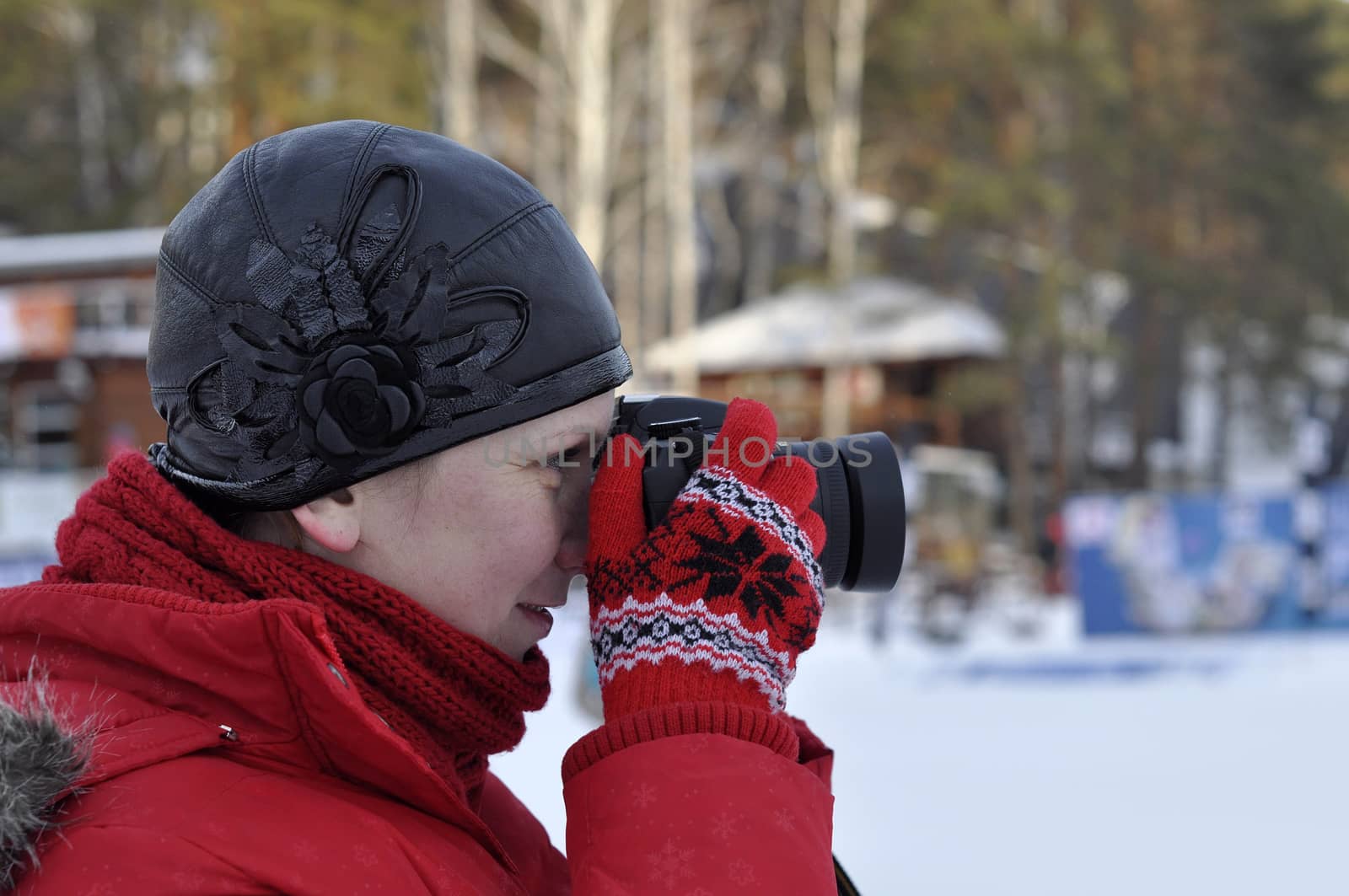 The woman in winter clothes photographs the SLR camera. by veronka72