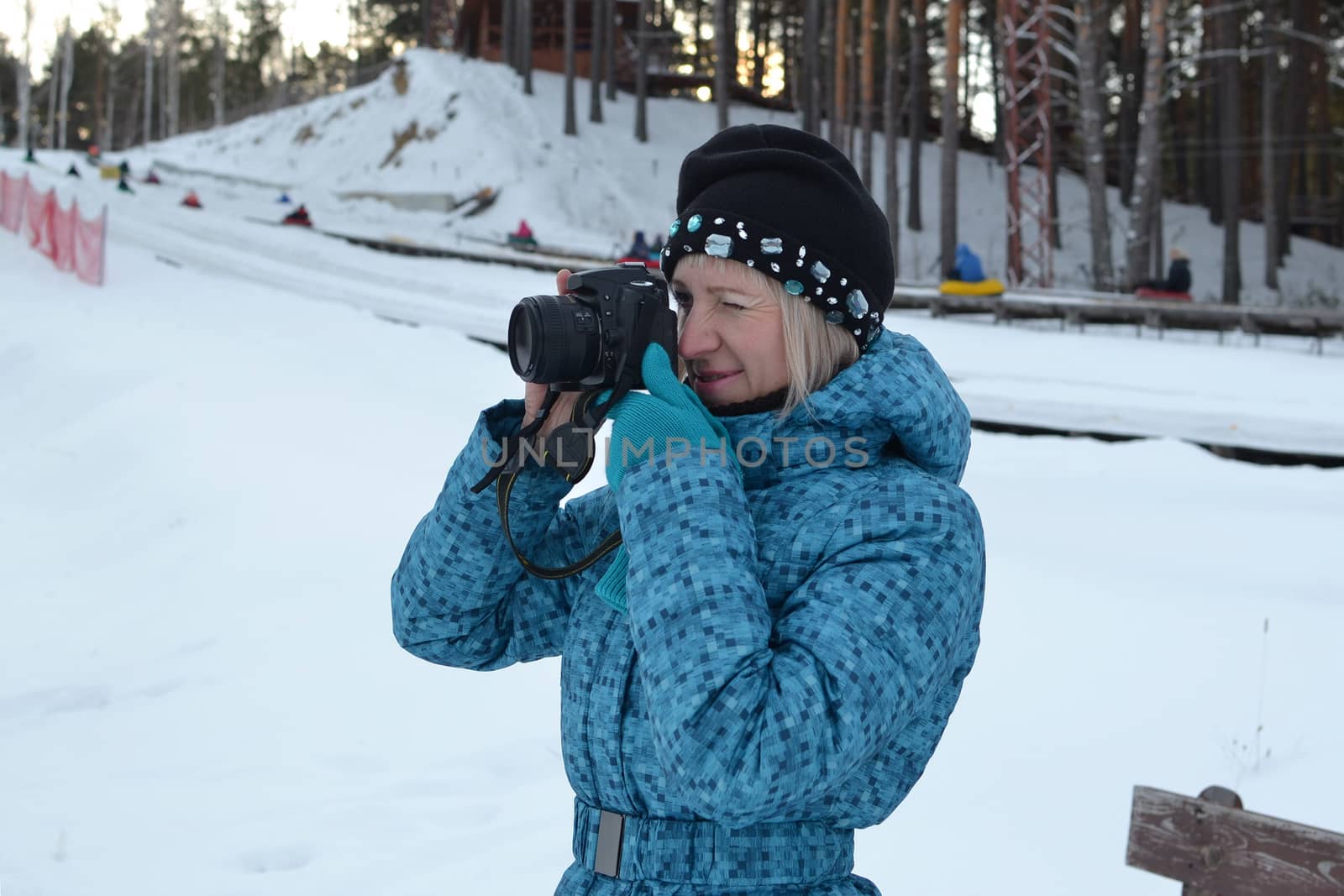The woman in winter clothes photographs the SLR camera. by veronka72