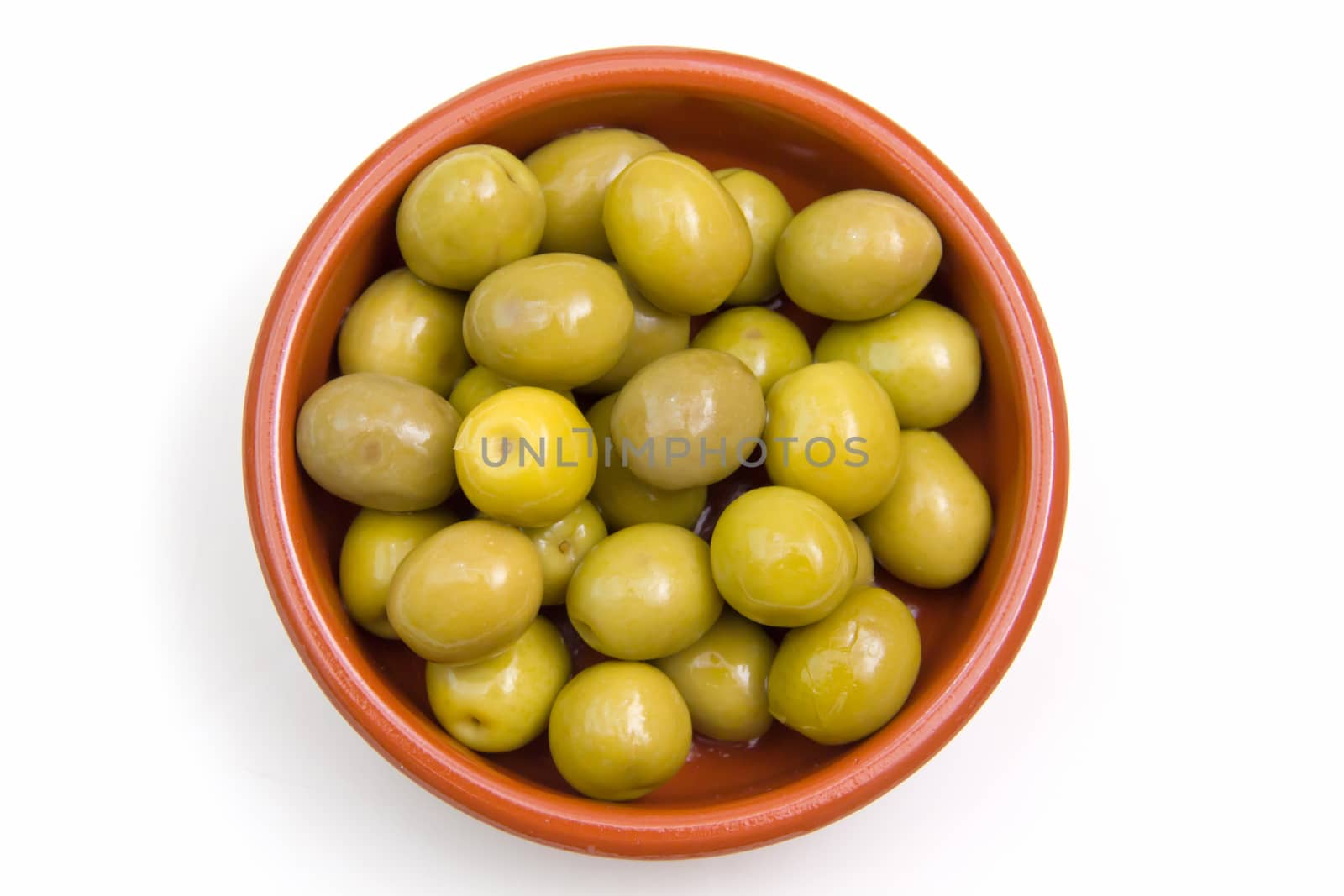 Olives on rustic bowl top view on white background