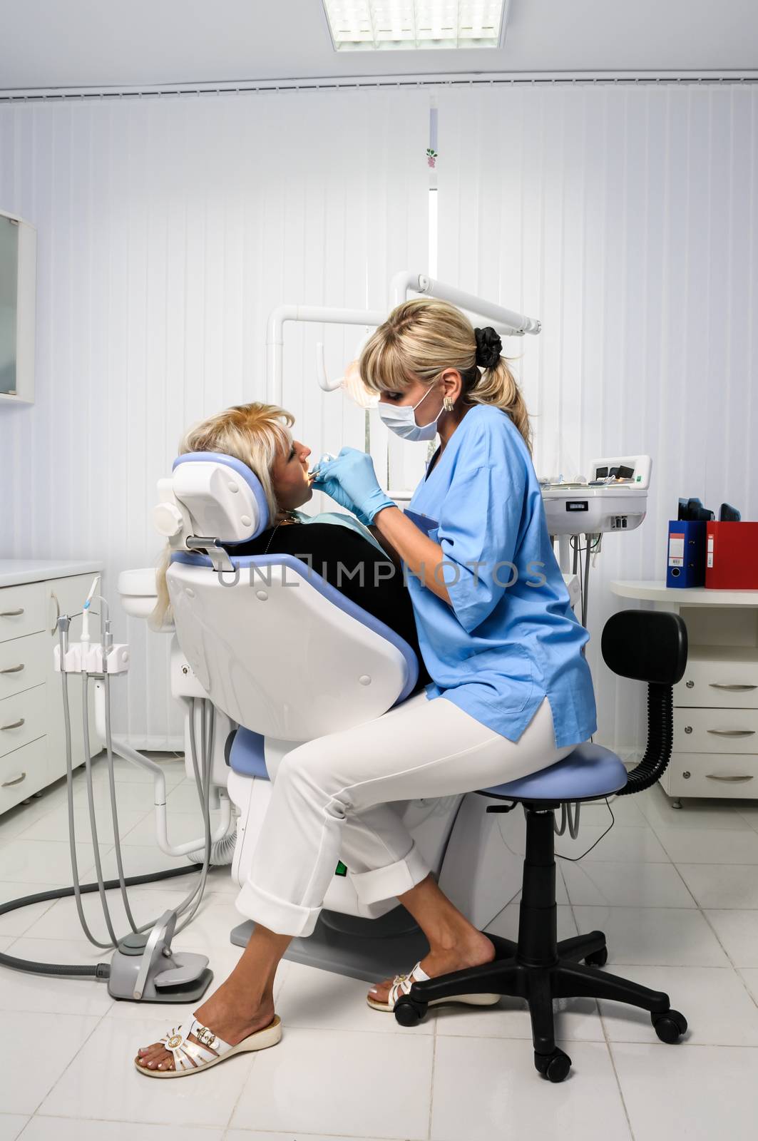 dentist at work with patient in office, dental exam