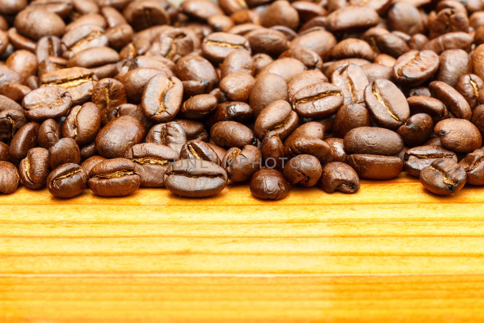 Close up of coffee beans on upper side and blank area at lower side on wooden table