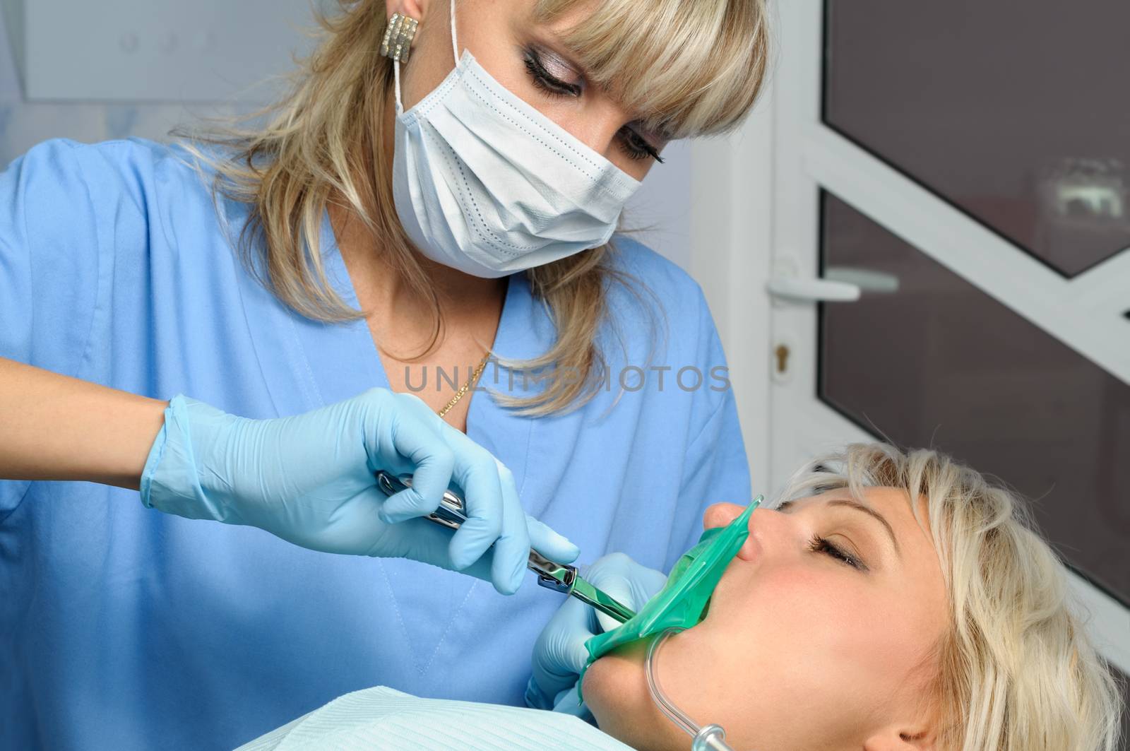 dentist at work with patient, installation of rubber dam or kofferdam