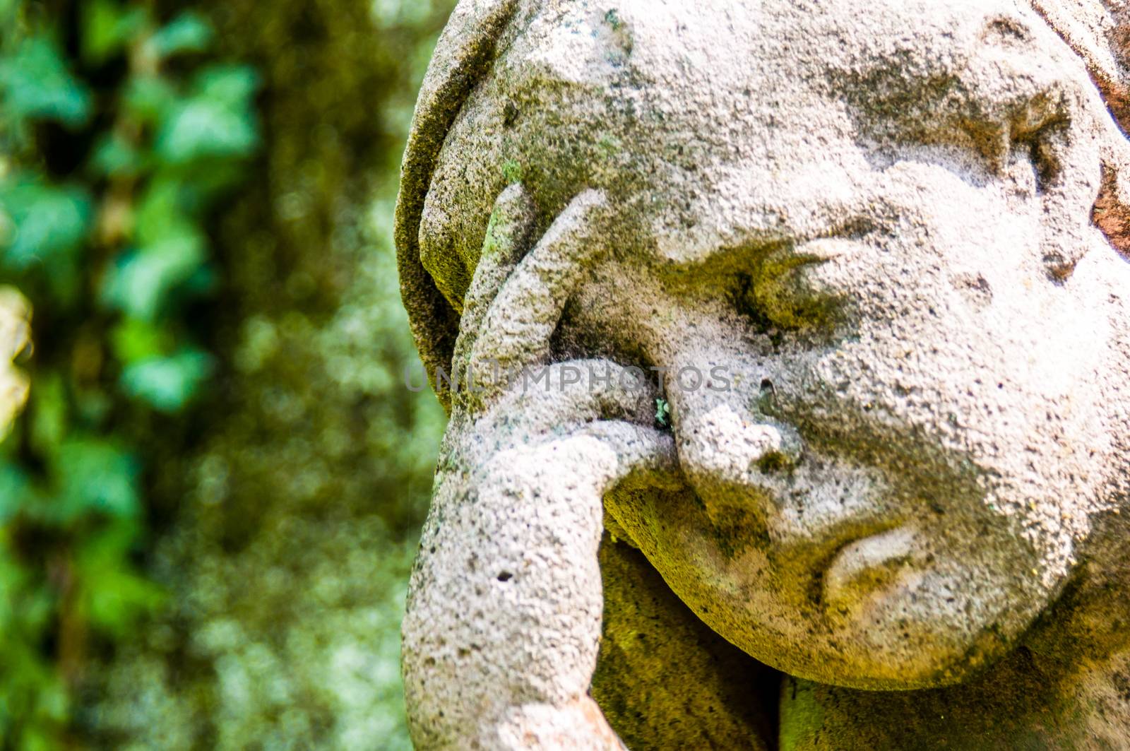 detail of a mourning sculpture on a cemetery