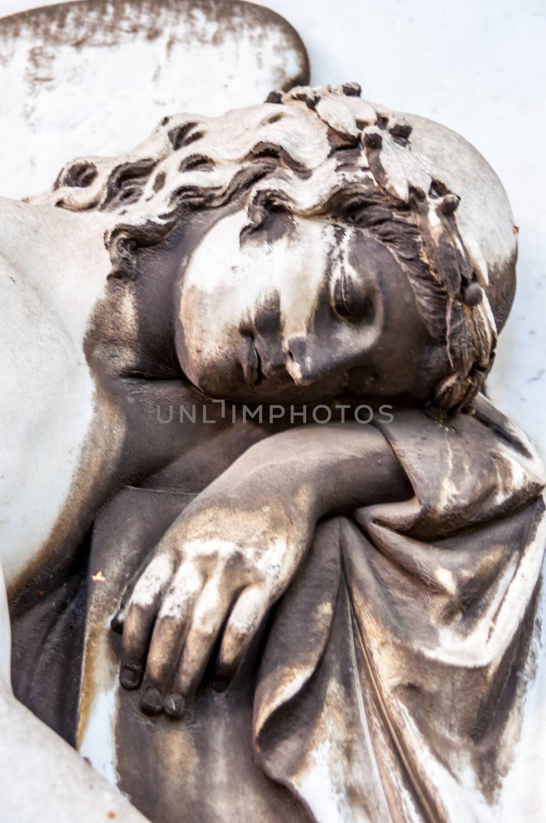 detail of a mourning sculpture on a cemetery