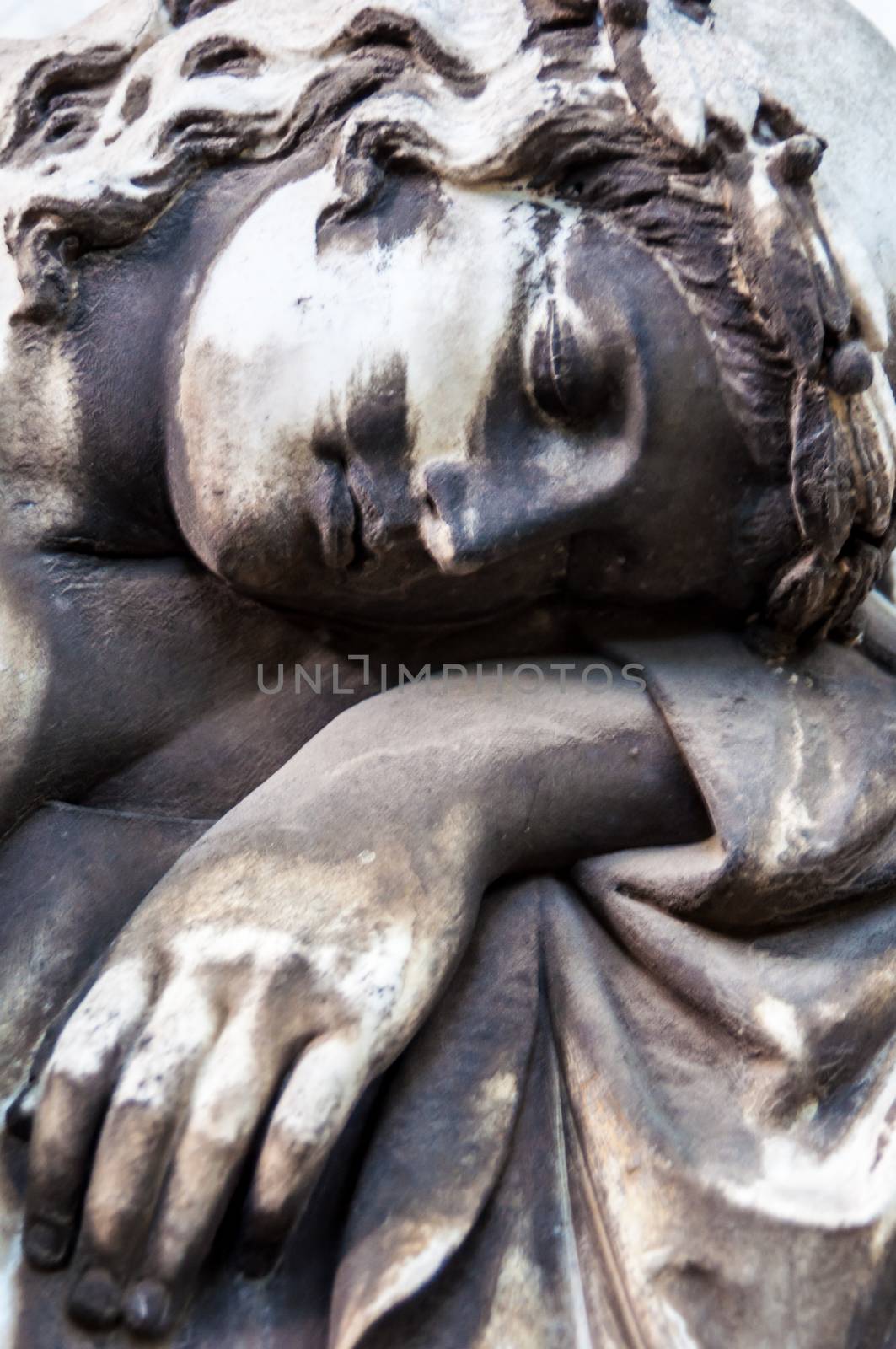 detail of a mourning sculpture on a cemetery