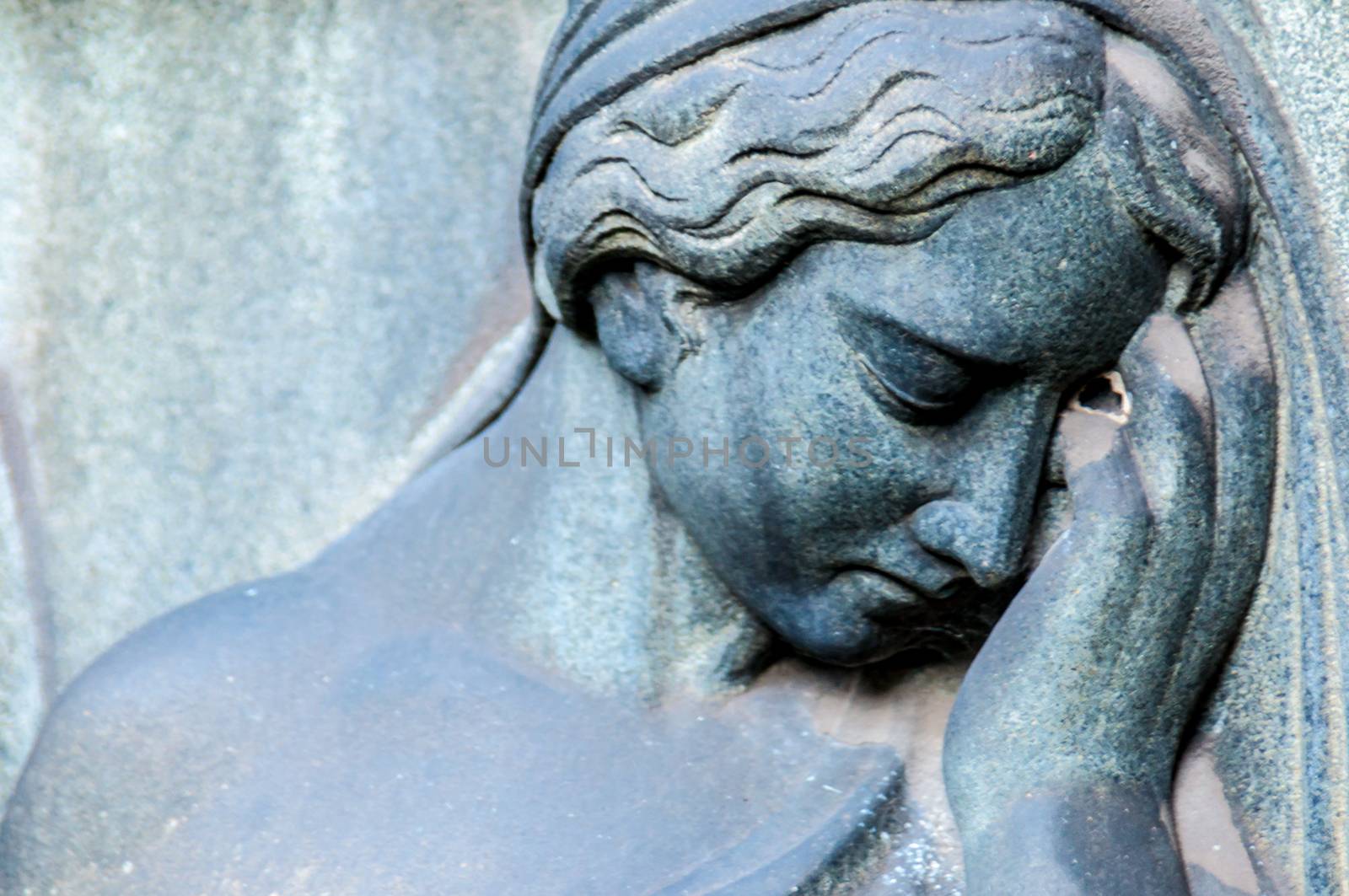 detail of a mourning sculpture on a cemetery