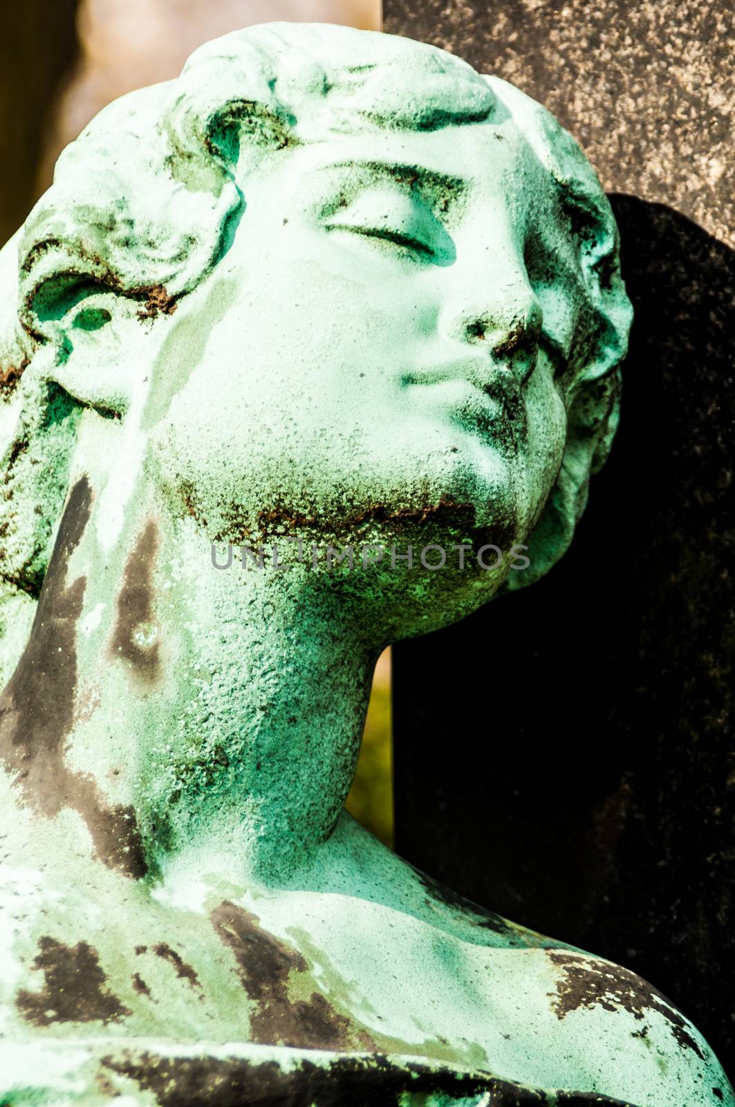 detail of a mourning sculpture on a cemetery