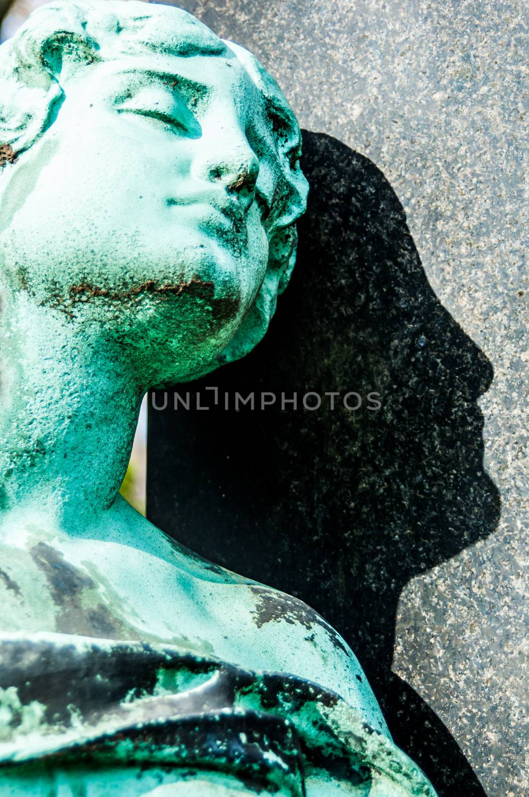 detail of a mourning sculpture on a cemetery