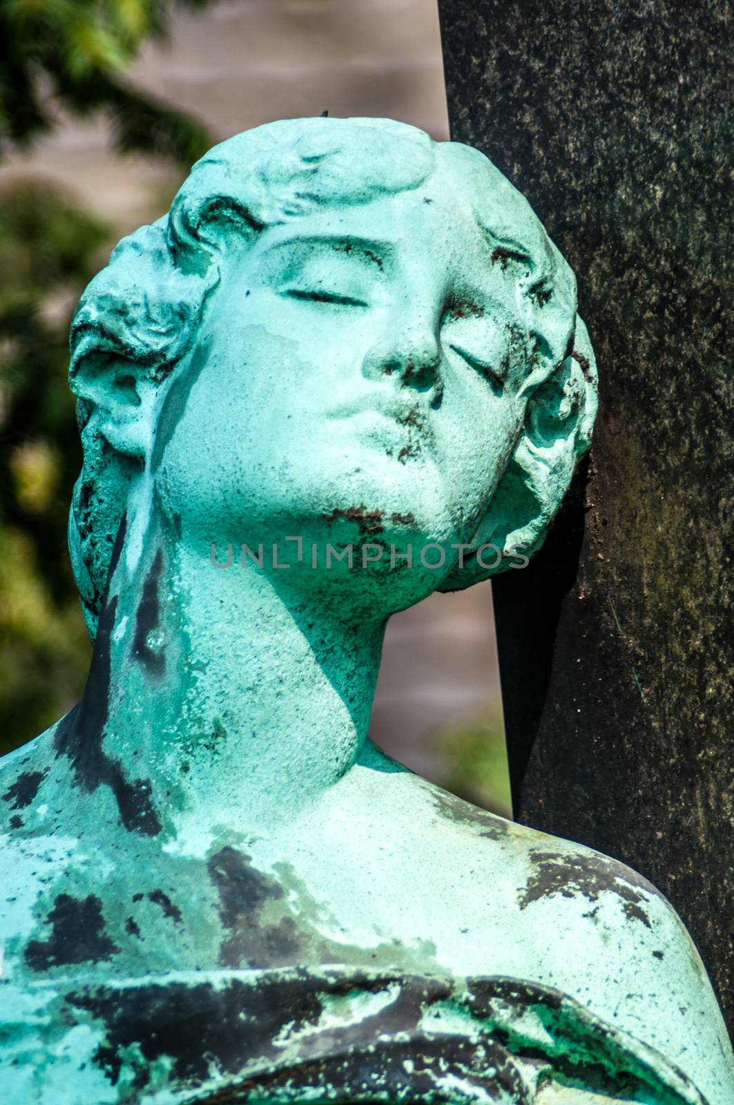 detail of a mourning sculpture on a cemetery