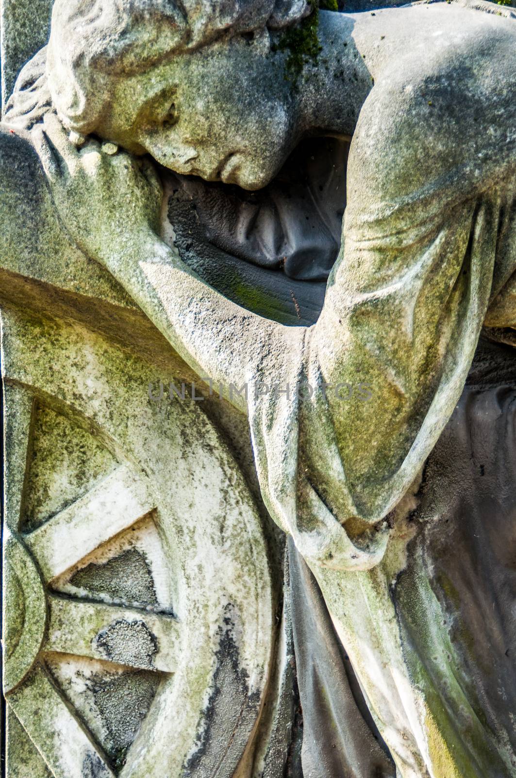 detail of a mourning sculpture on a cemetery