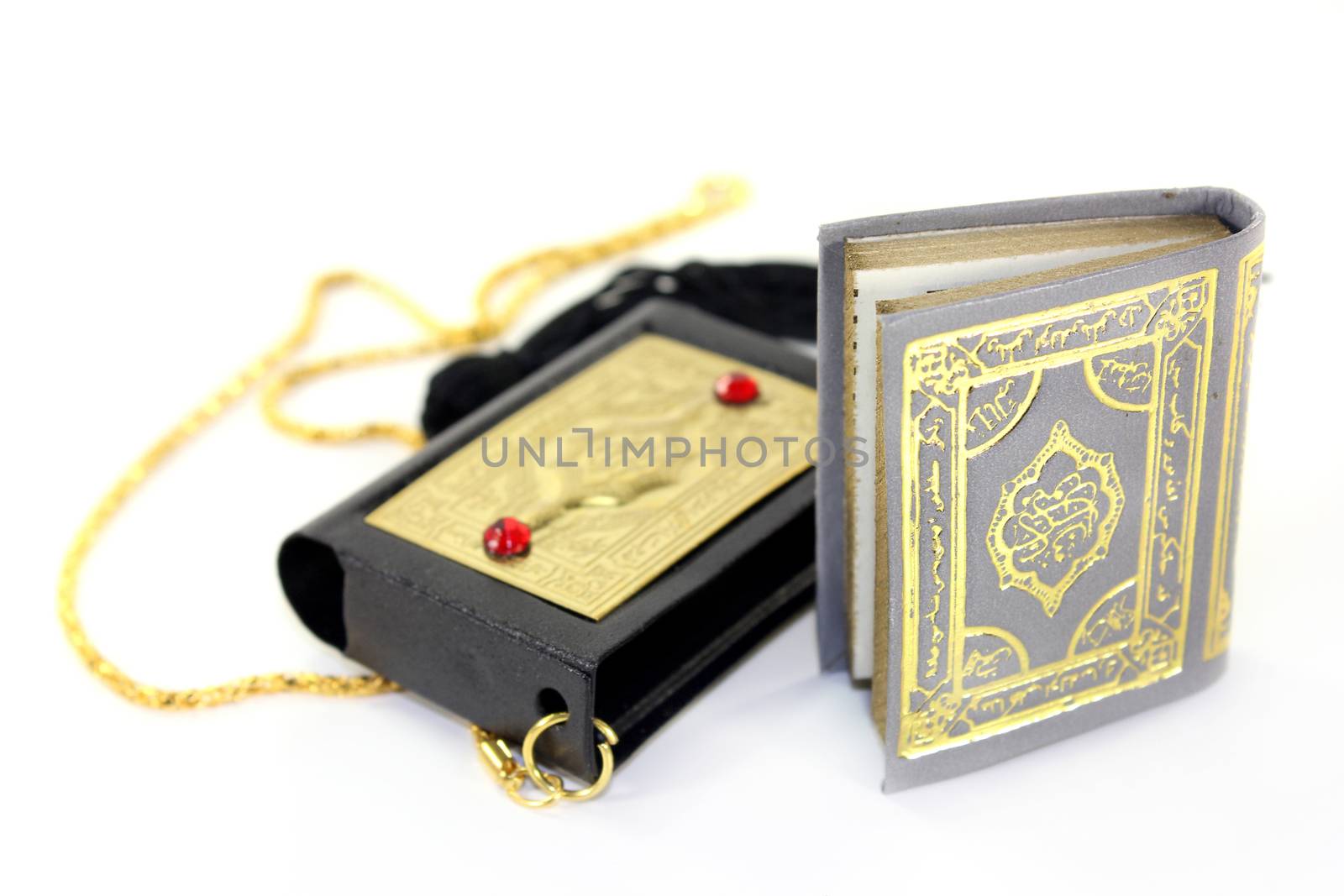 Quran with a cover and chain in front of white background