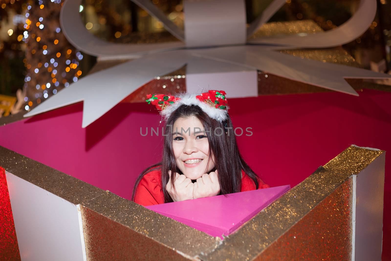 Santa woman dressing in a large gift box. Smiling, happy and fun during Christmas.