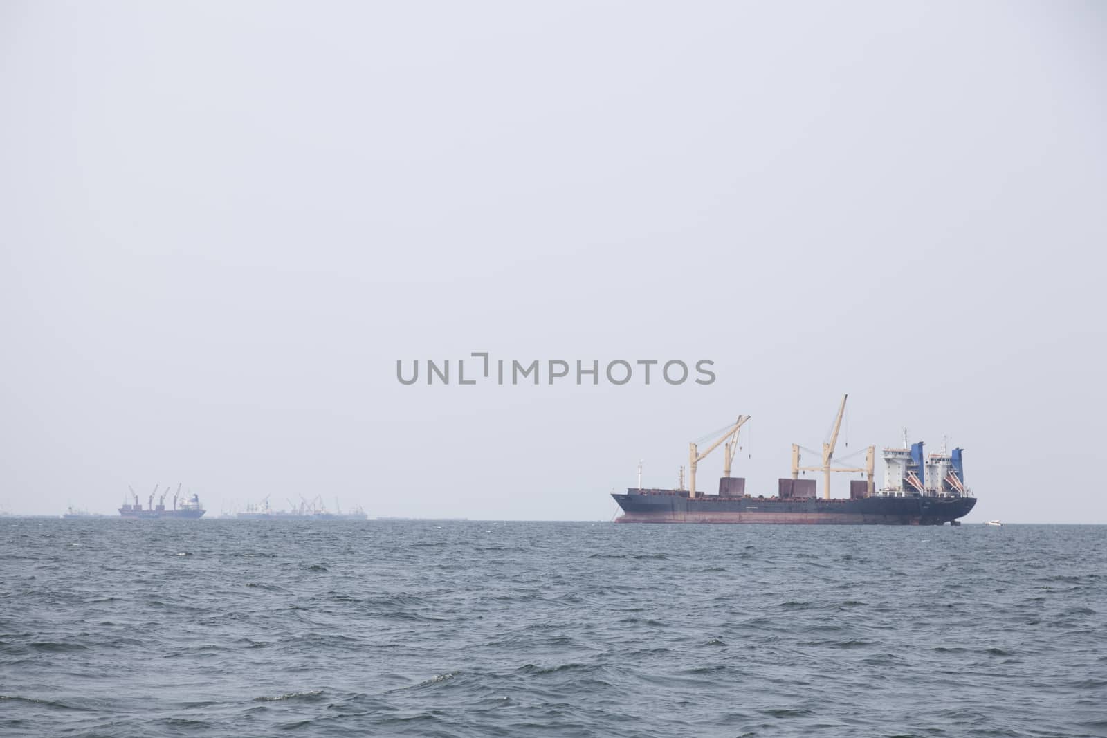 Large cargo ship Boats moored in the sea to make sense compared to the coast.