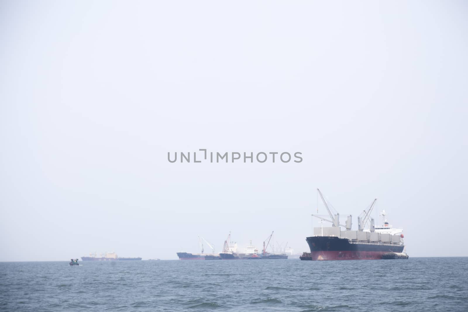 Large cargo ship Boats moored in the sea to make sense compared to the coast.