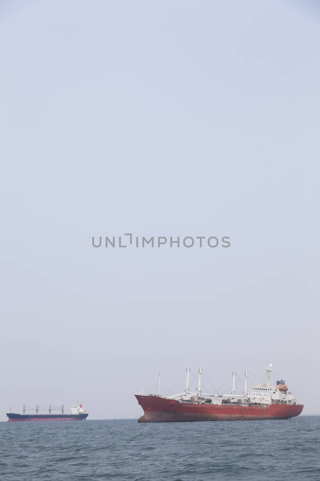 Large cargo ship Boats moored in the sea to make sense compared to the coast.