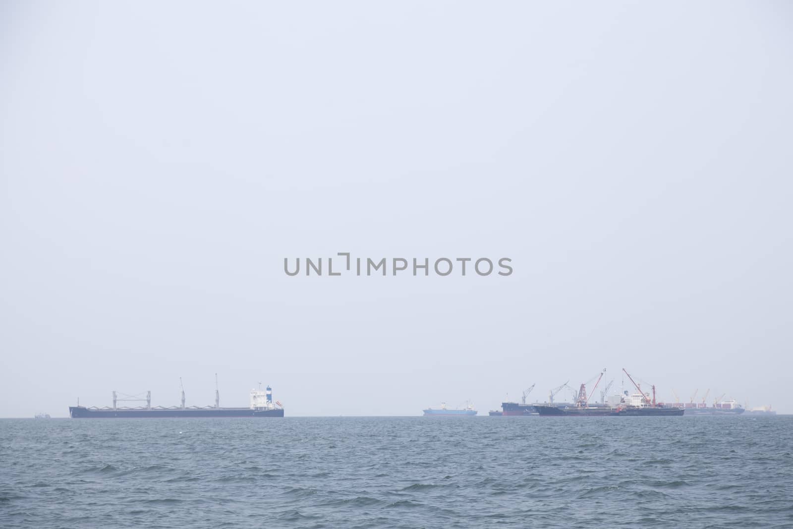 Large cargo ship Boats moored in the sea to make sense compared to the coast.