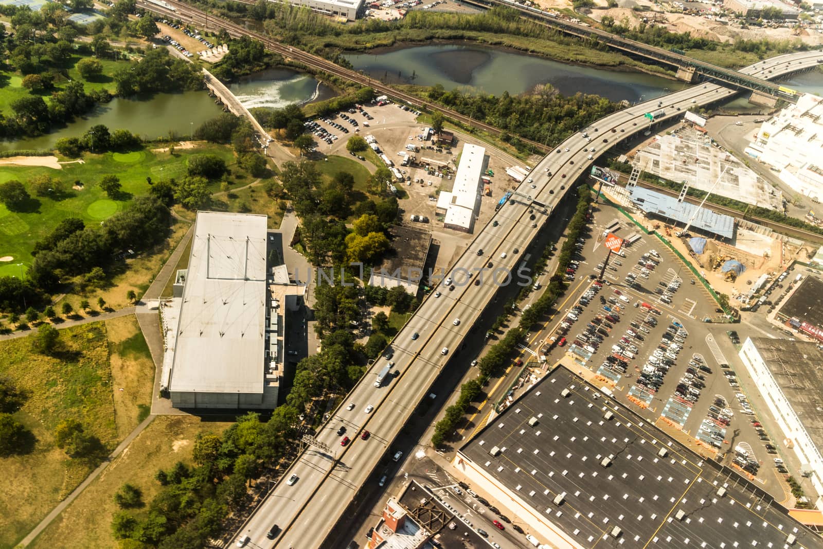 Aerial view of the Borough of Queens, New York, showing densely packed buildings and a multi-lane super highway