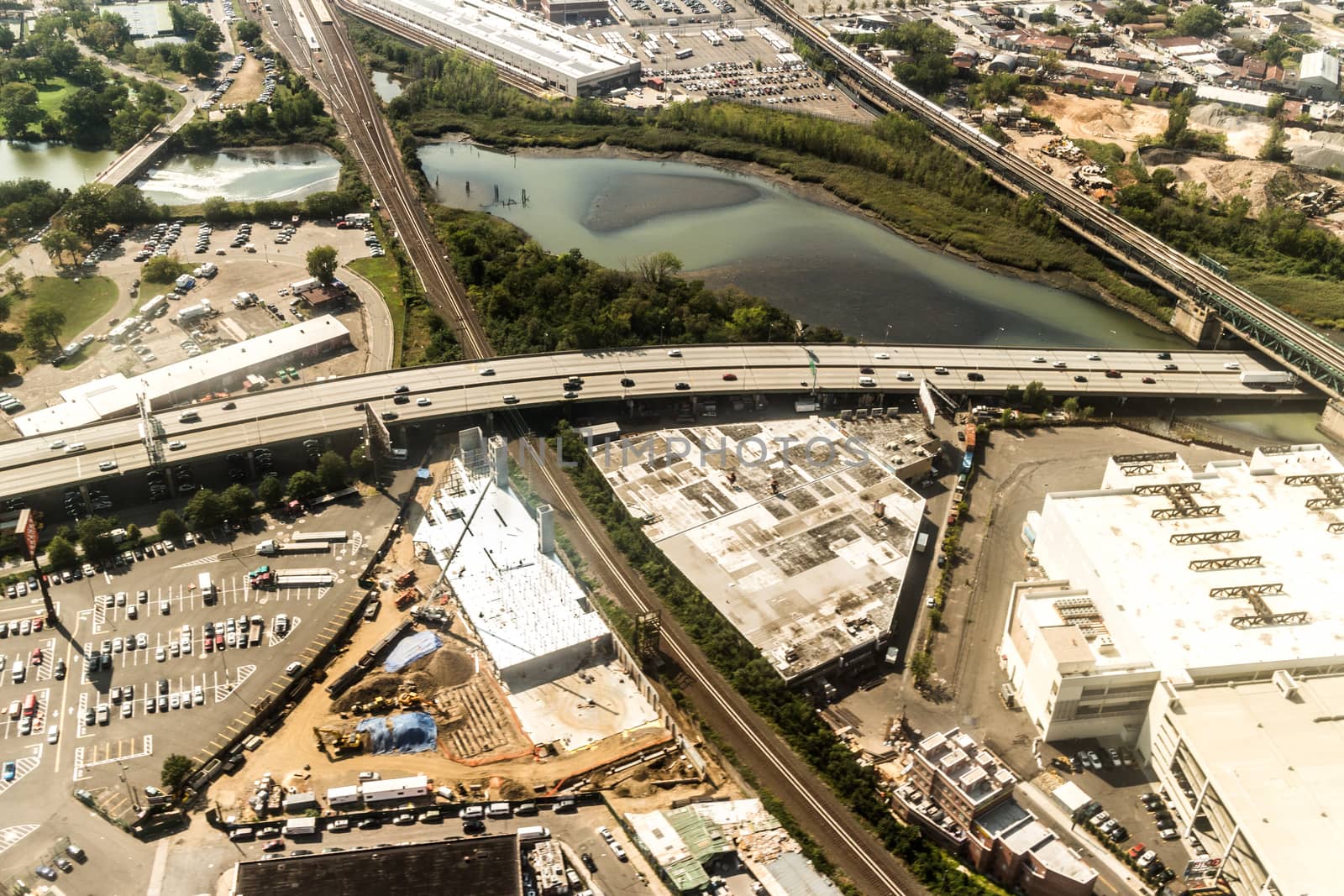 Aerial view of the Borough of Queens, New York, showing densely packed buildings and a multi-lane super highway