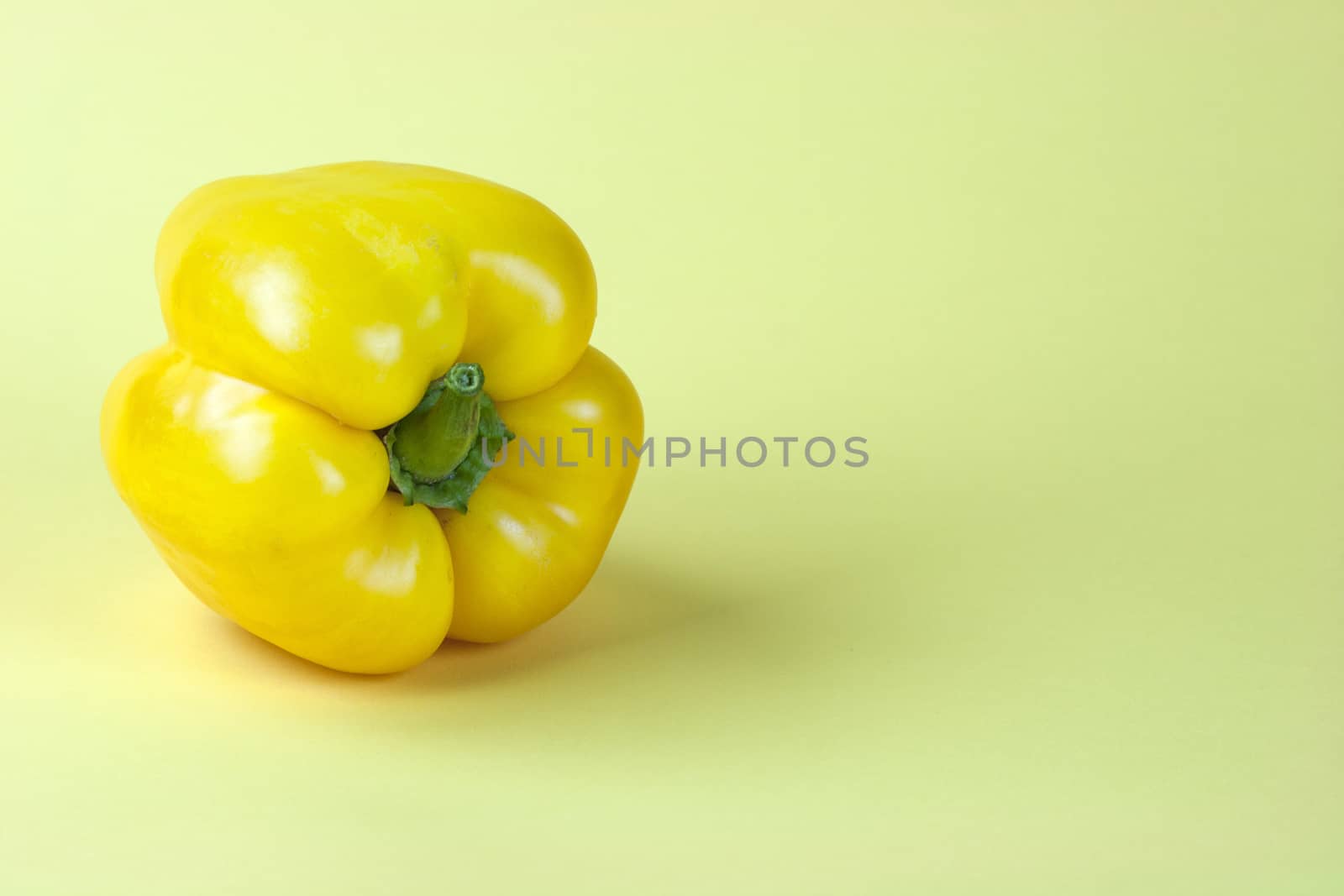 Sweet yellow pepper isolated on yellow background