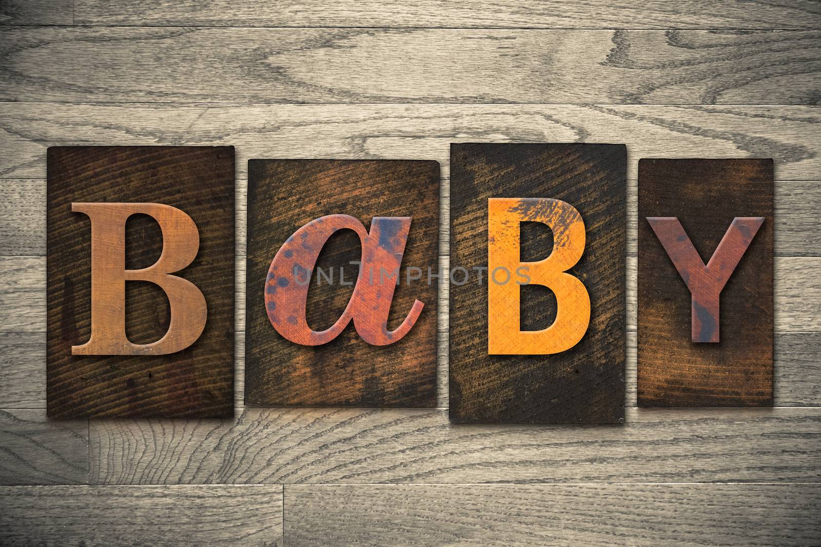 The word "BABY" written in wooden letterpress type.