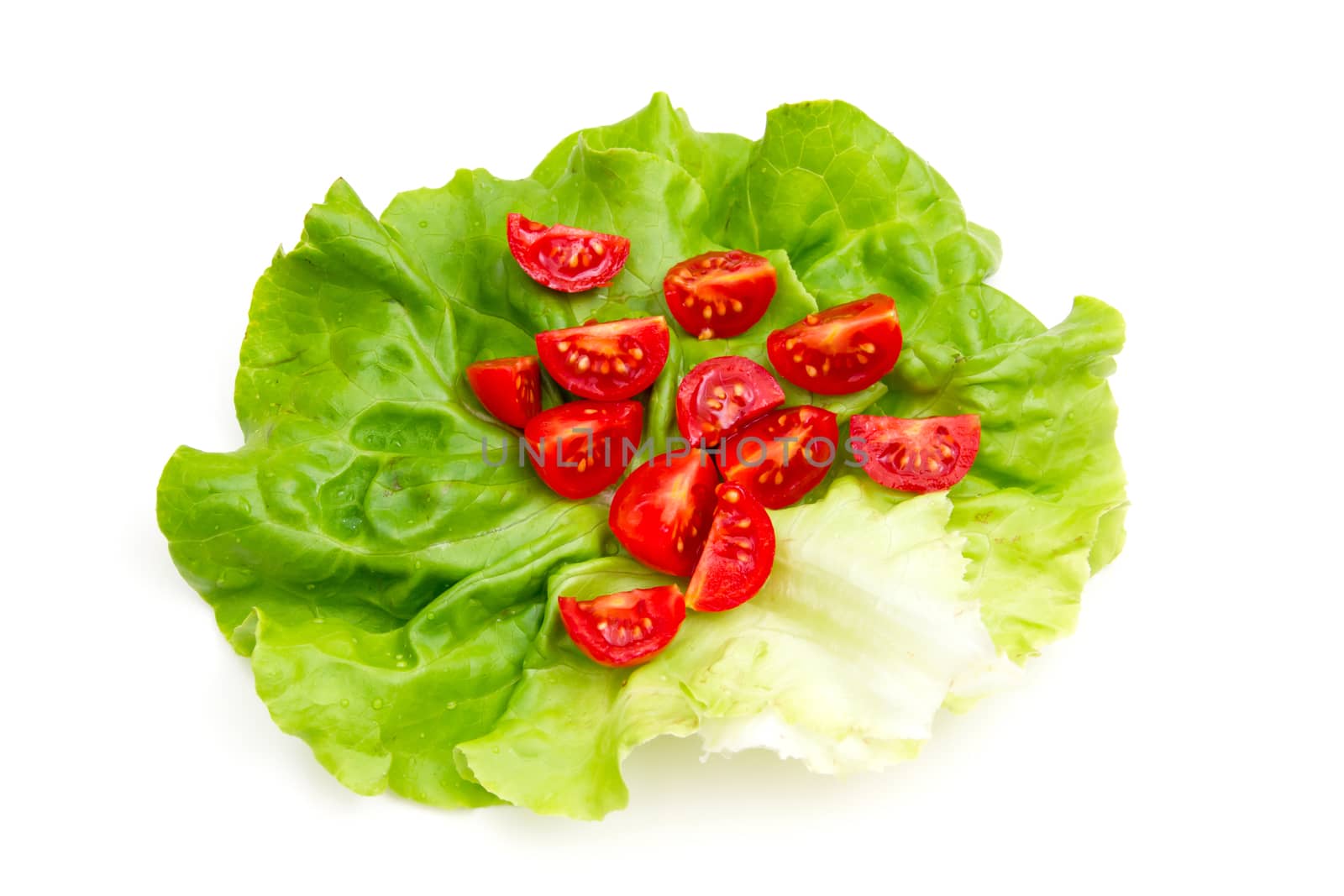 Cherry tomatoes on lettuce on white background