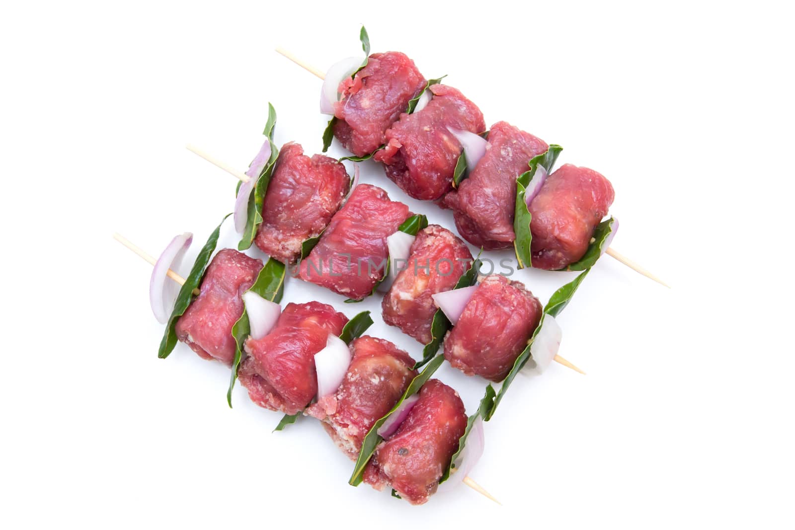 Skewers of meat from above on white background