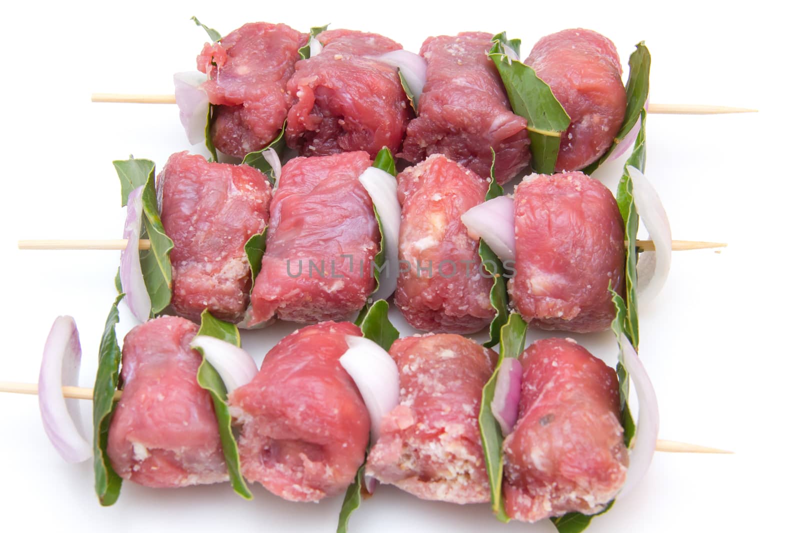 Skewers of meat on white background