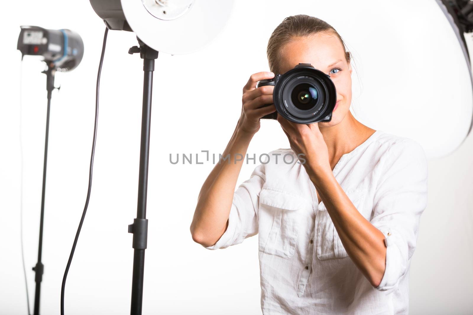 Pretty, female photographer with digital camera - DSLR and a huge telephoto lens (color toned image; shallow DOF)