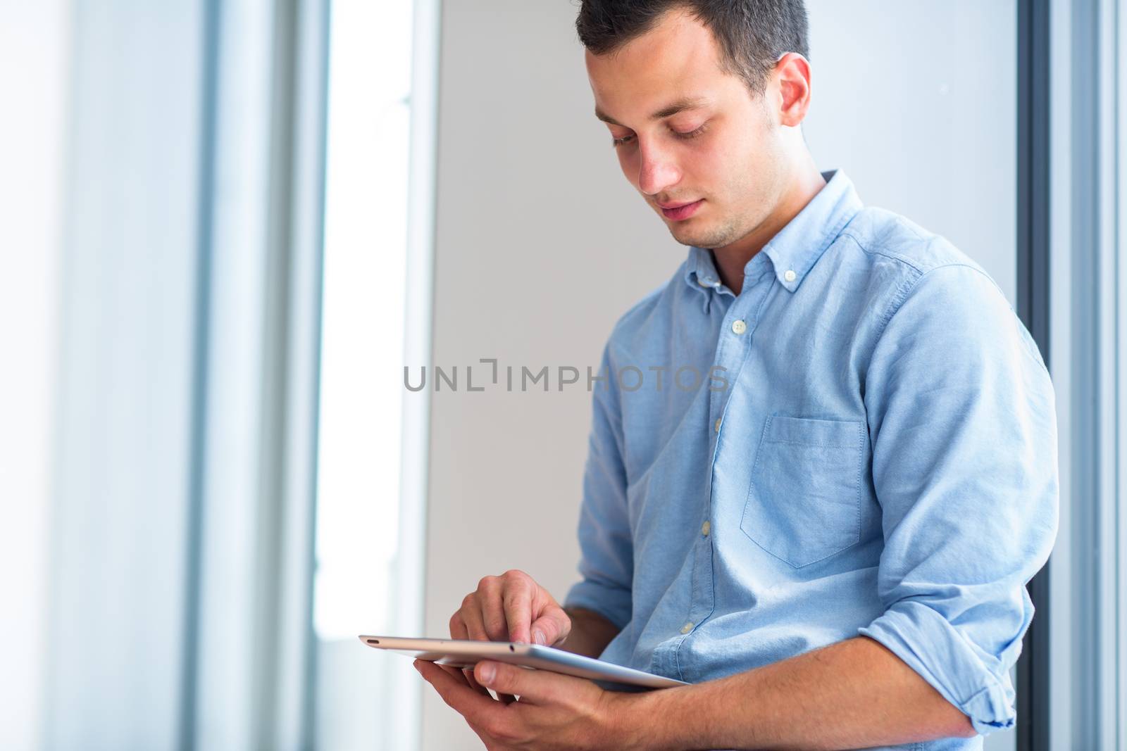 Handsome young man using his tablet computer by viktor_cap