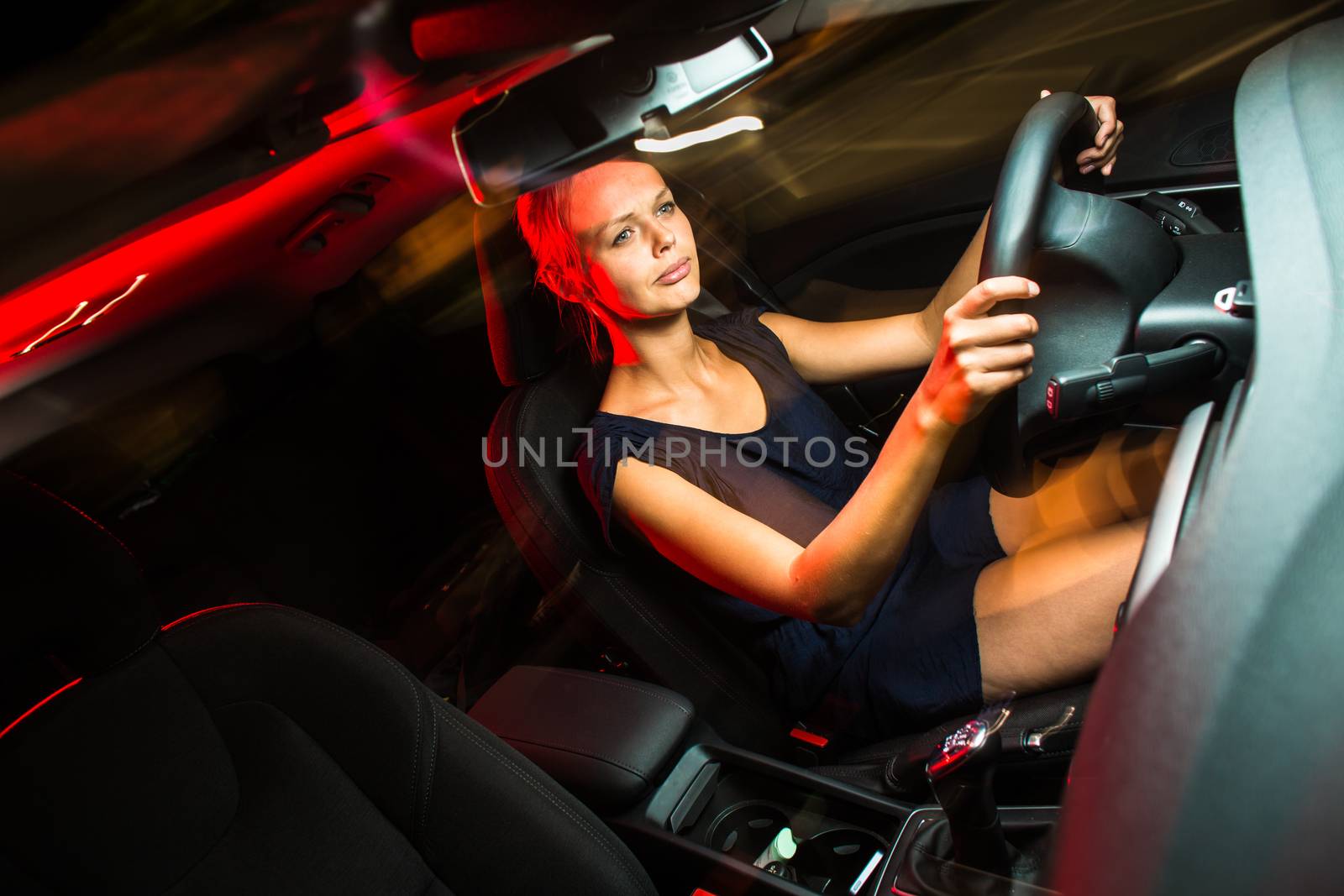 Driving a car at night - pretty, young woman driving her car by viktor_cap