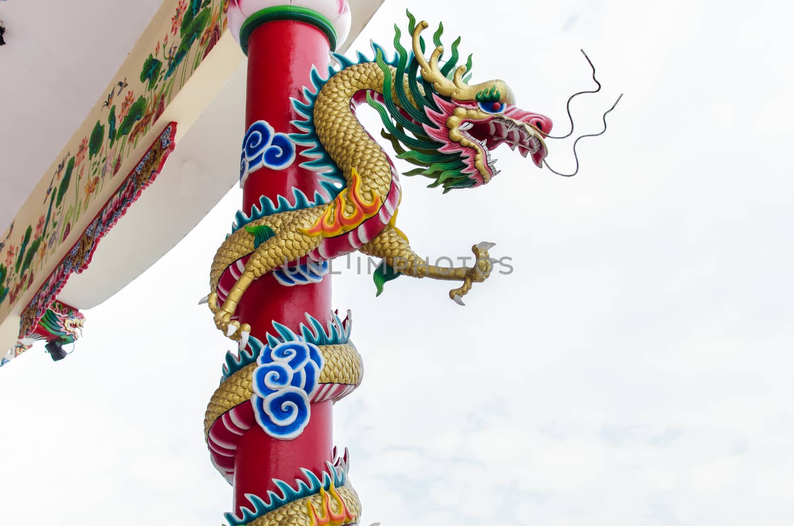 Dragon winding around the pole in chinese shrine in Thailand by wanichs