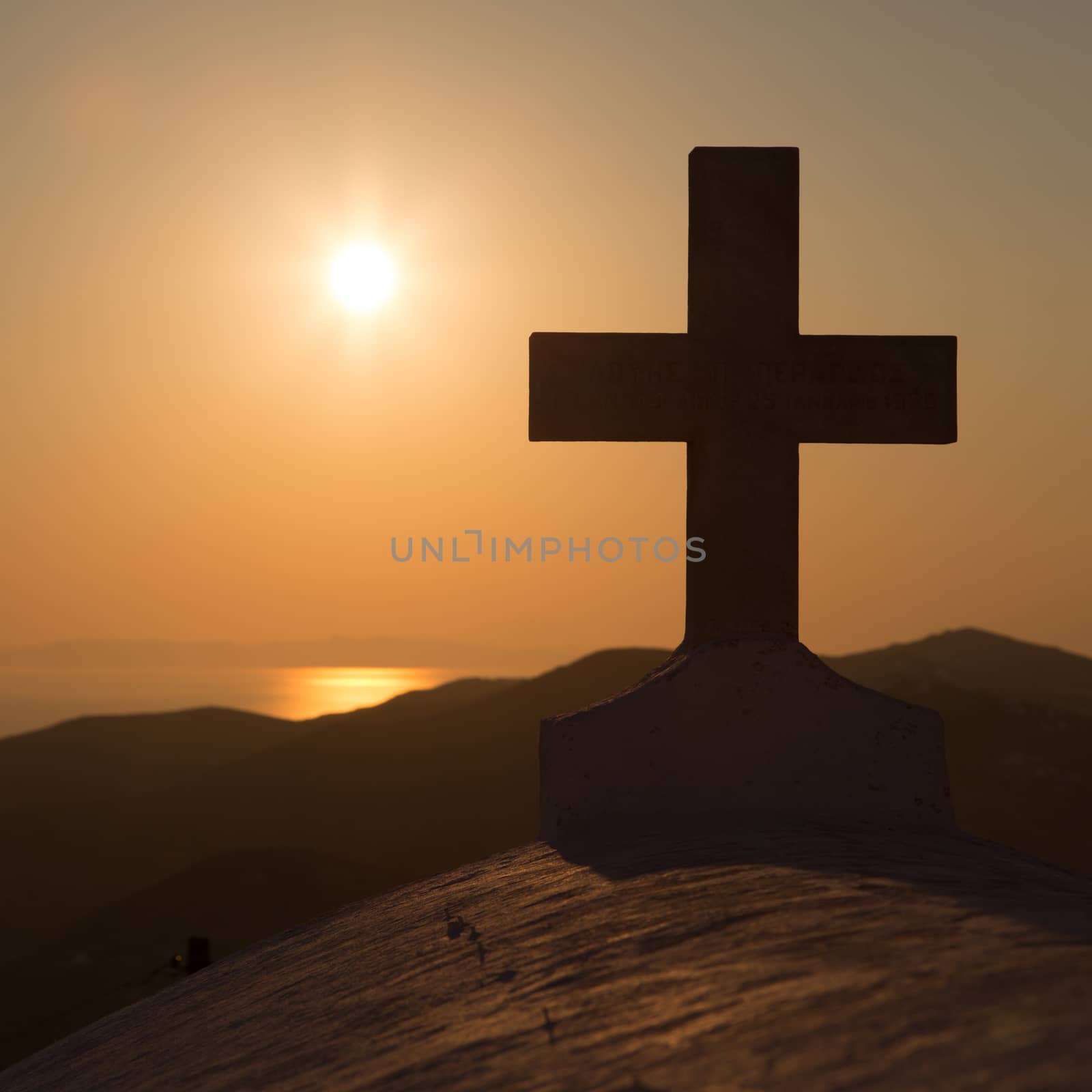 Sunset and the cross of the church at the top of the hill in Chora, Folegandros