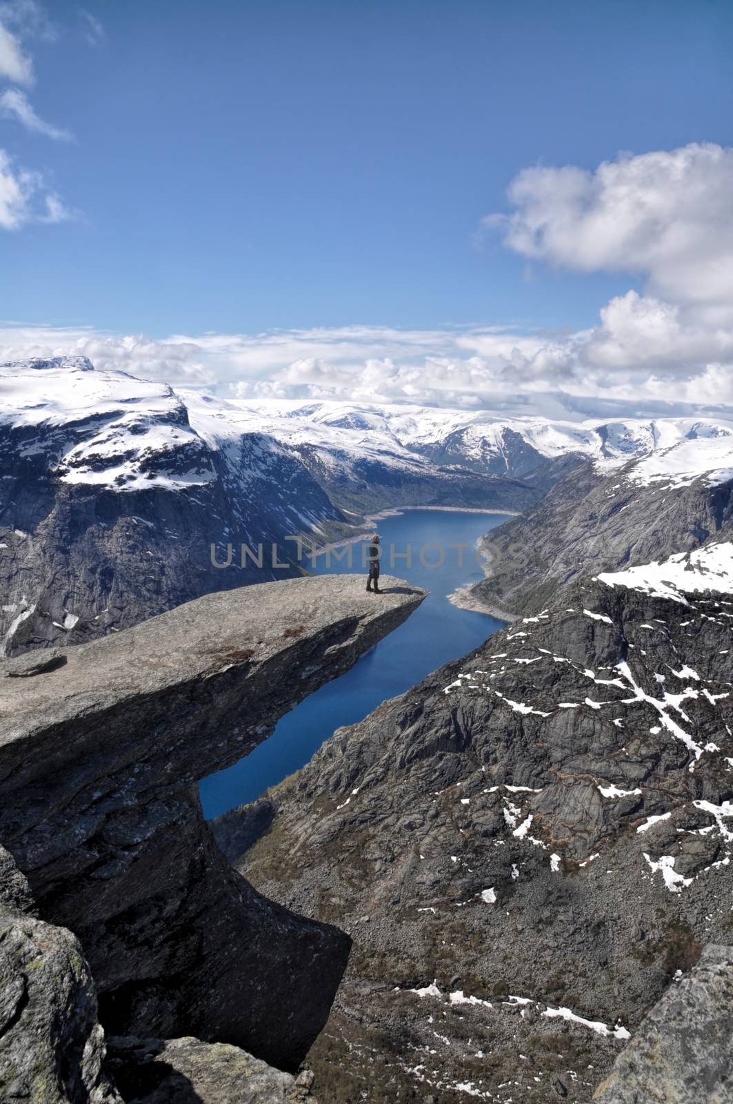 Lonely hiker standing at the edge of Trolltunga rock, Norway